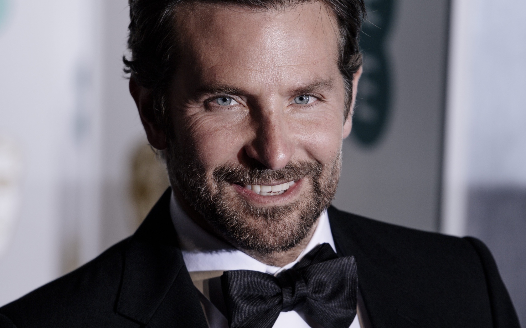 Улыбающийся актер Брэдли Купер в костюме