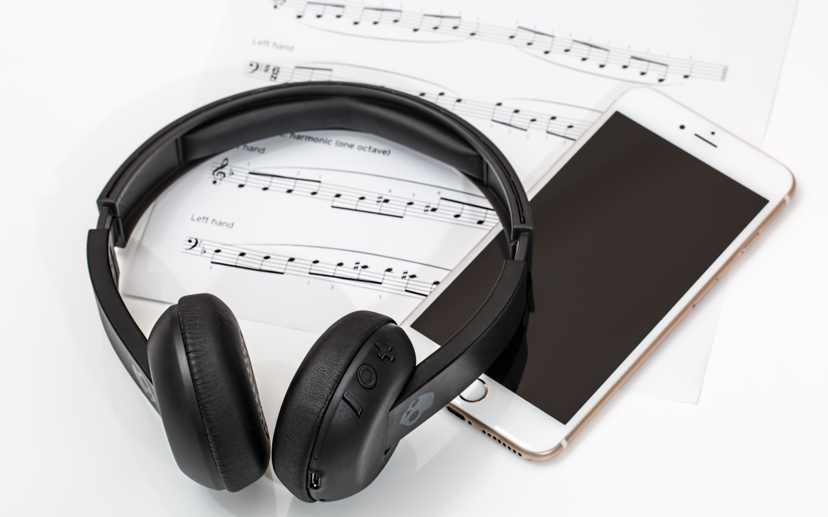 Наушники на столе с нотами и смартфоном