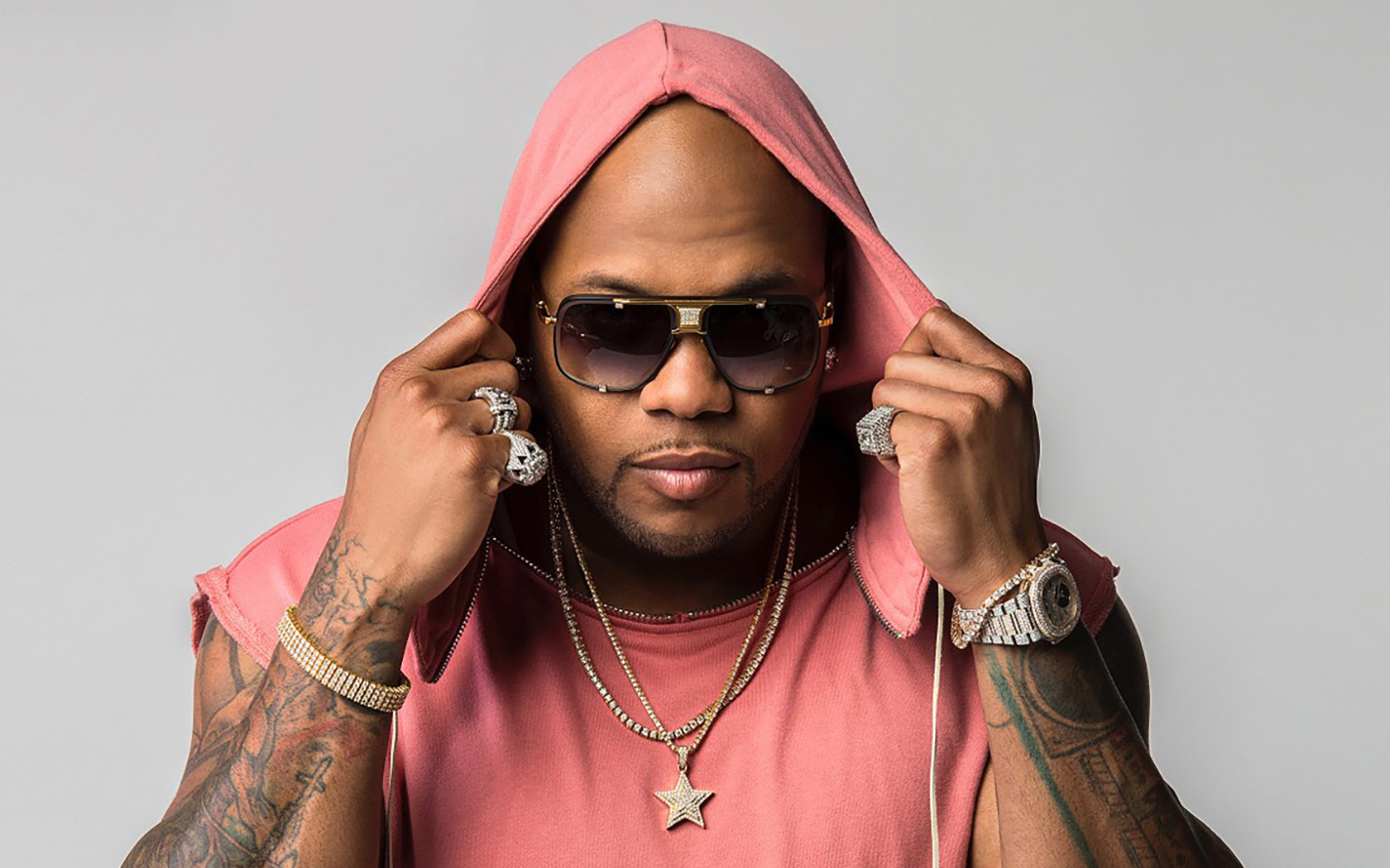 Рэпер Flo Rida на сером фоне