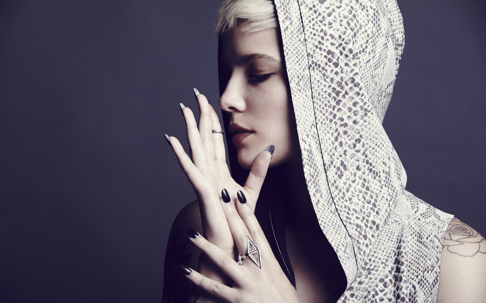 Певица Холзи в капюшоне на сером фоне