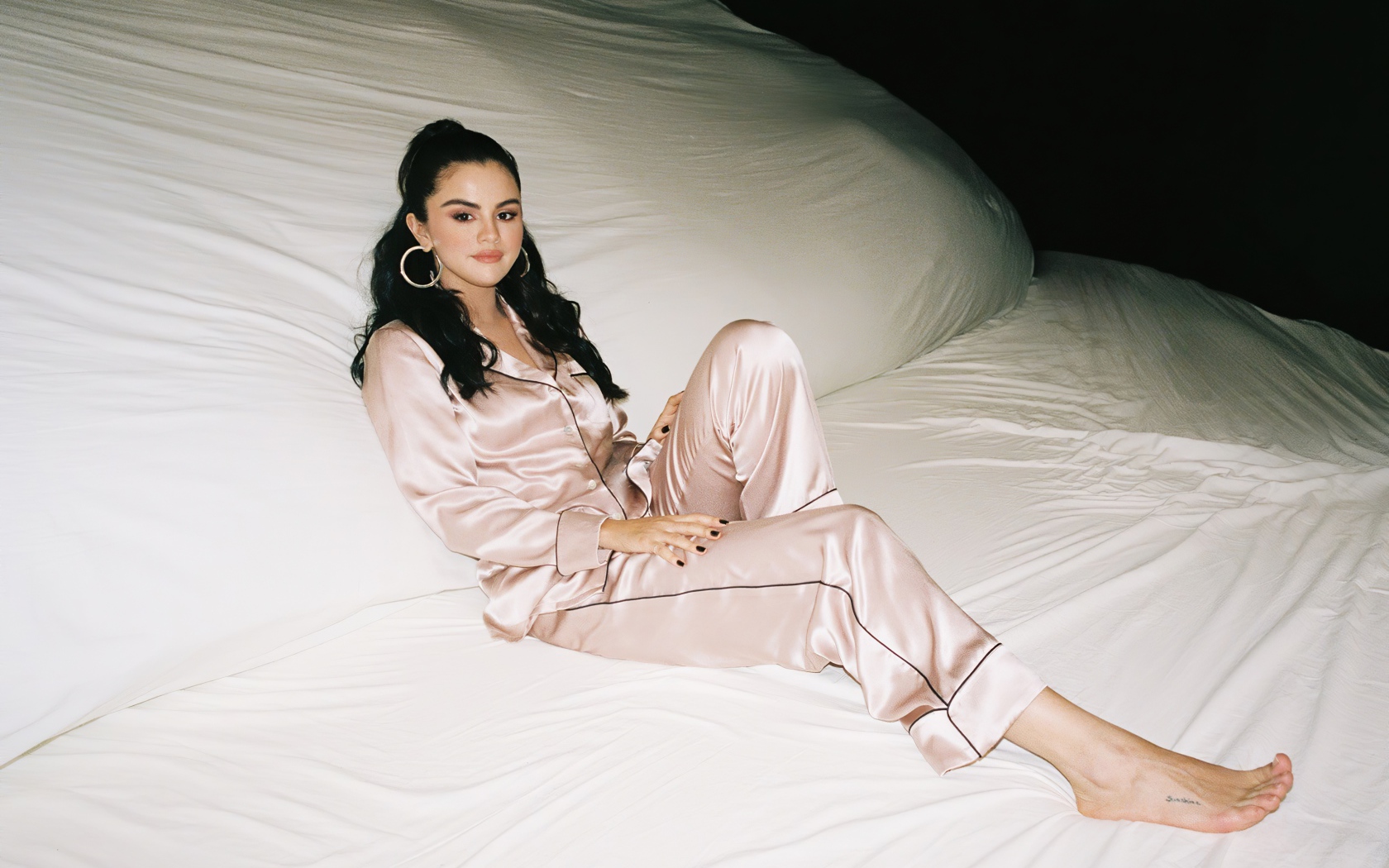 Певица Селена Гомез в пижаме на большой белой кровати