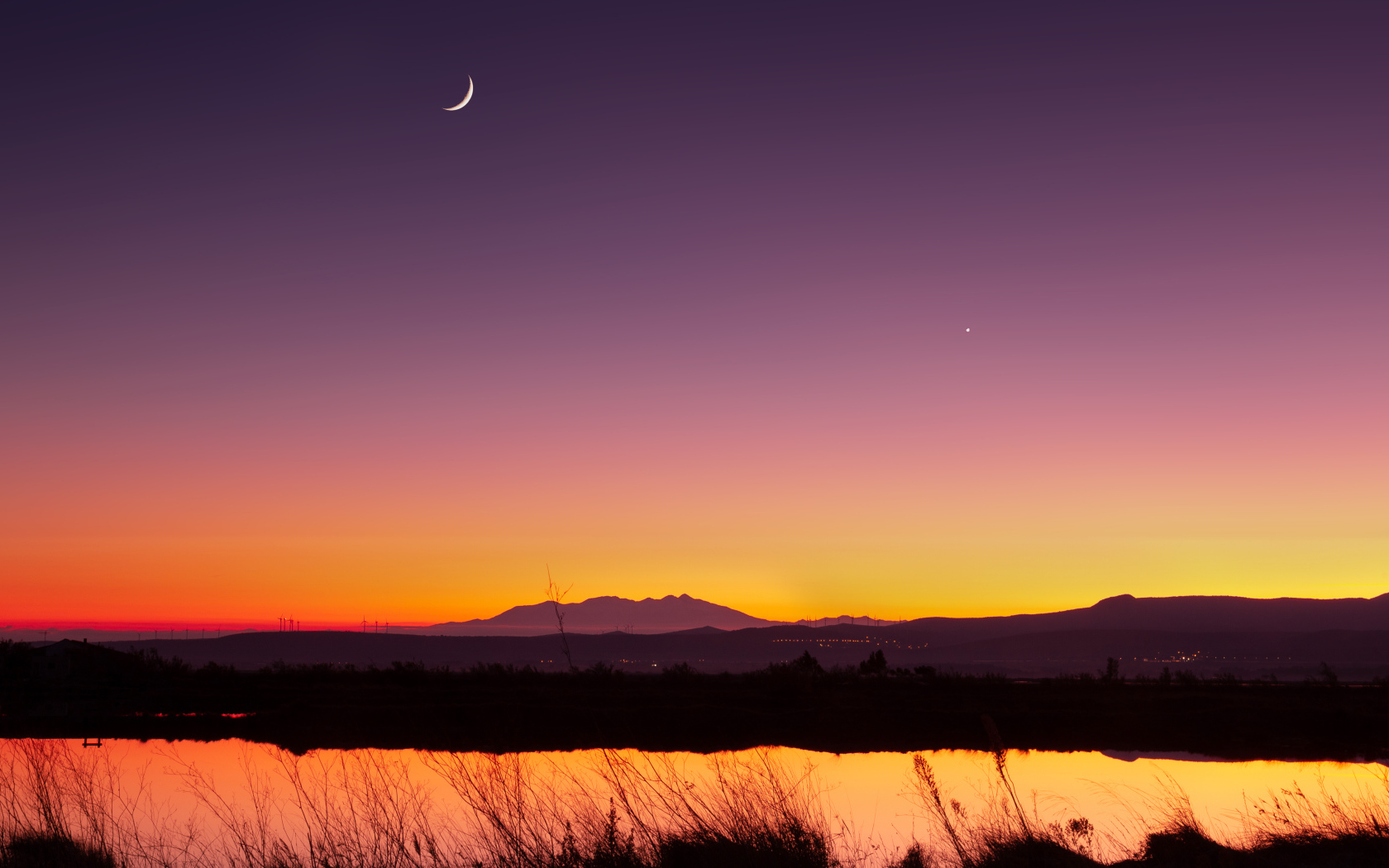 Молодой месяц в небе над озером ночью 