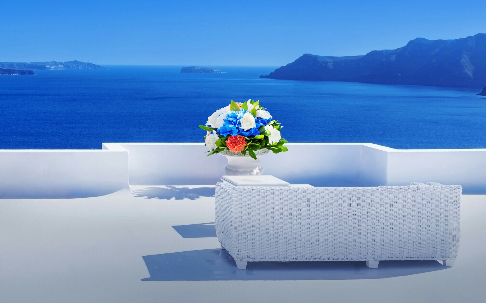 Красивый букет цветов на белом столе на фоне моря