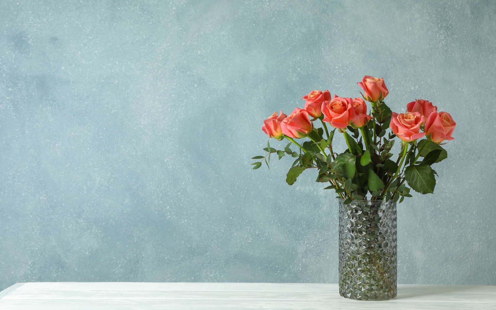 Bouquet of roses in a glass vase on a gray background