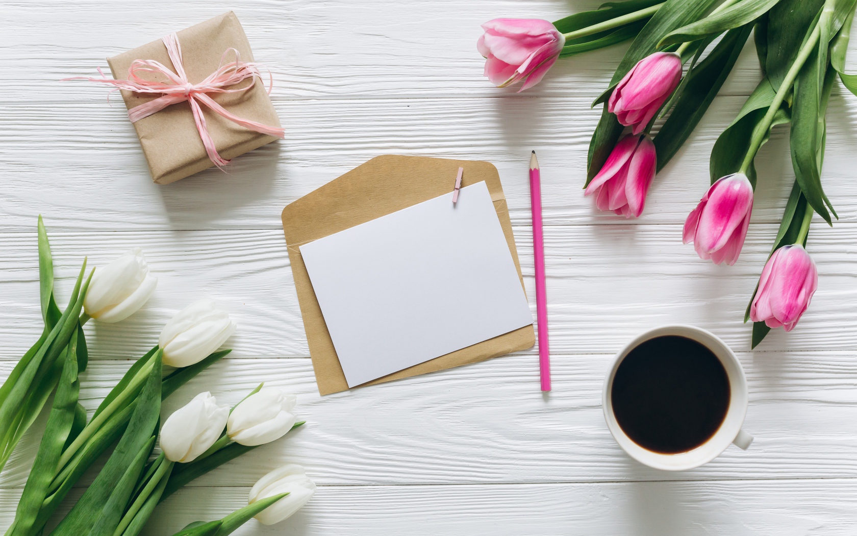 Два букета тюльпанов на столе с подарком, кофе и письмом
