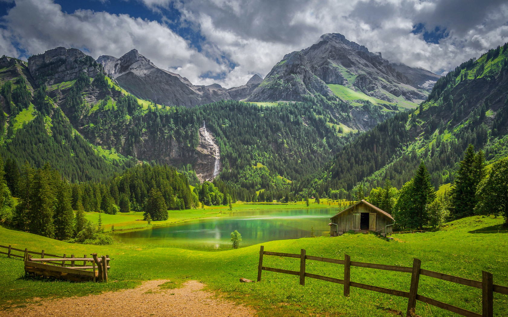 Красивые покрытые зелеными деревьями горы у озера