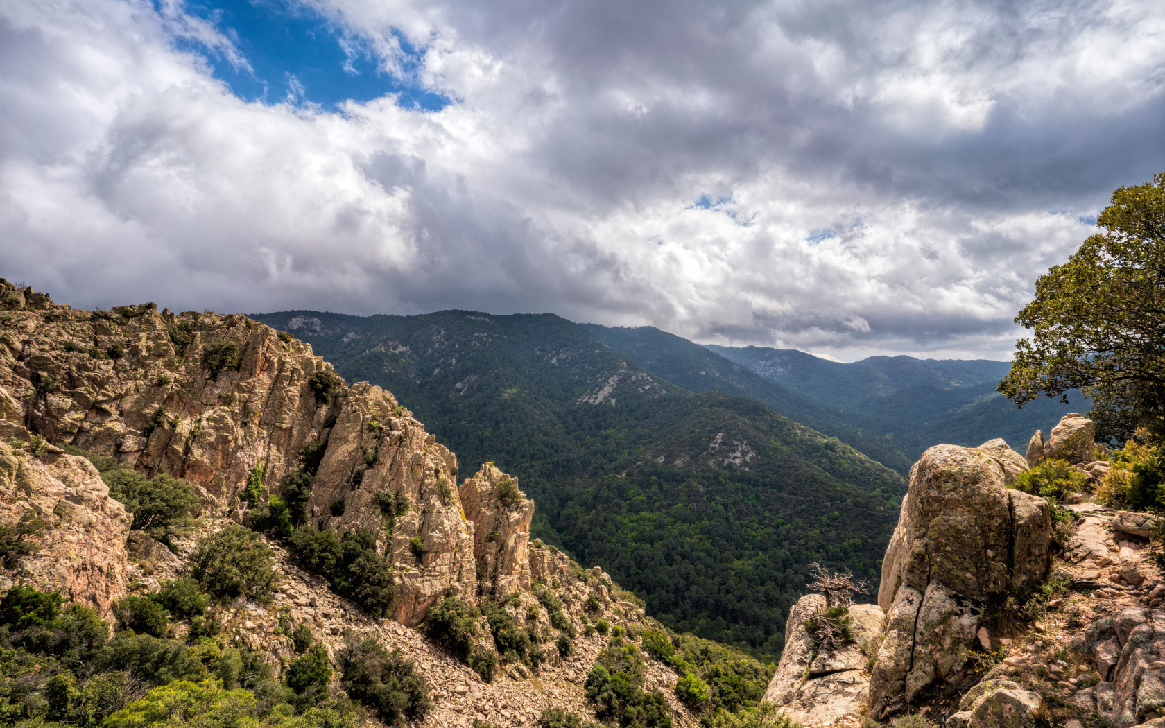 Зеленые вершины гор под белыми облаками 