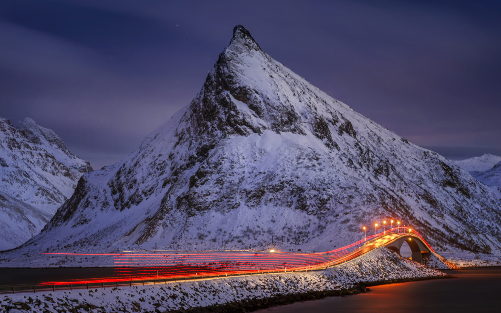 Ночная дорога у заснеженных гор 