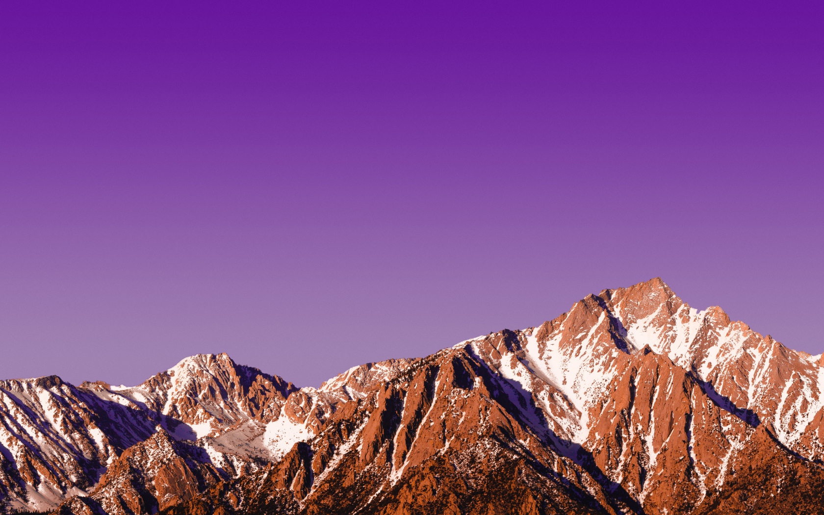 Вершины заснеженных гор на фоне сиреневого заката