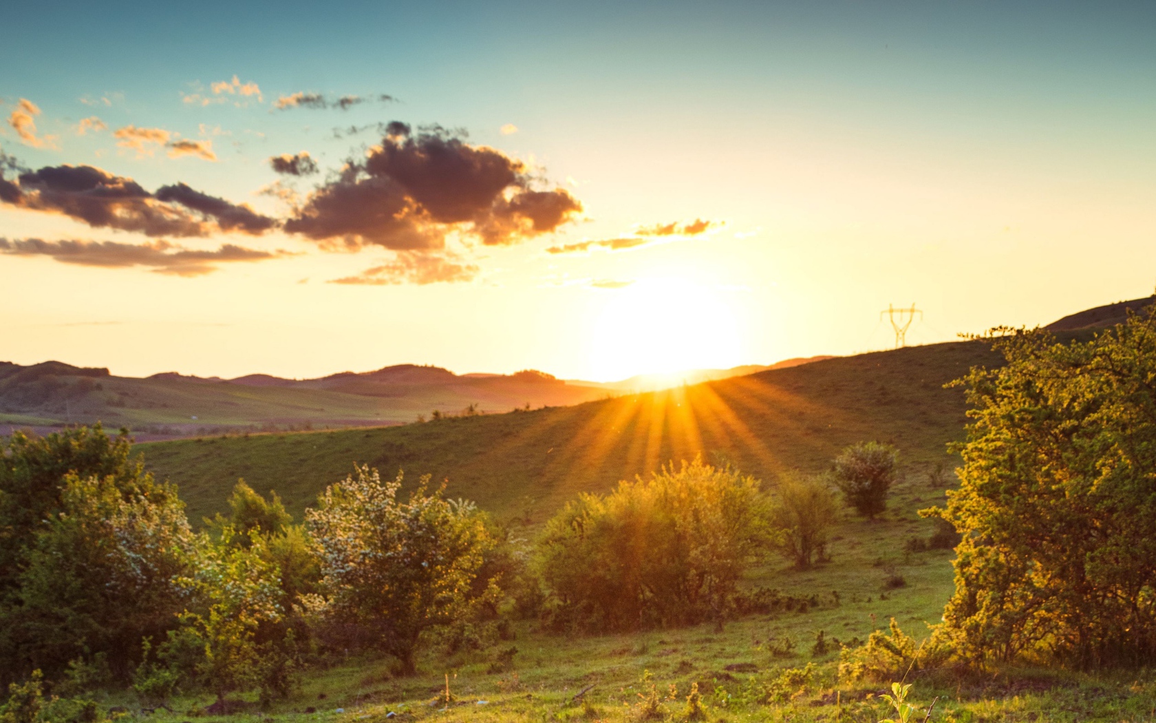 Яркое летнее солнце встает из-за гор 