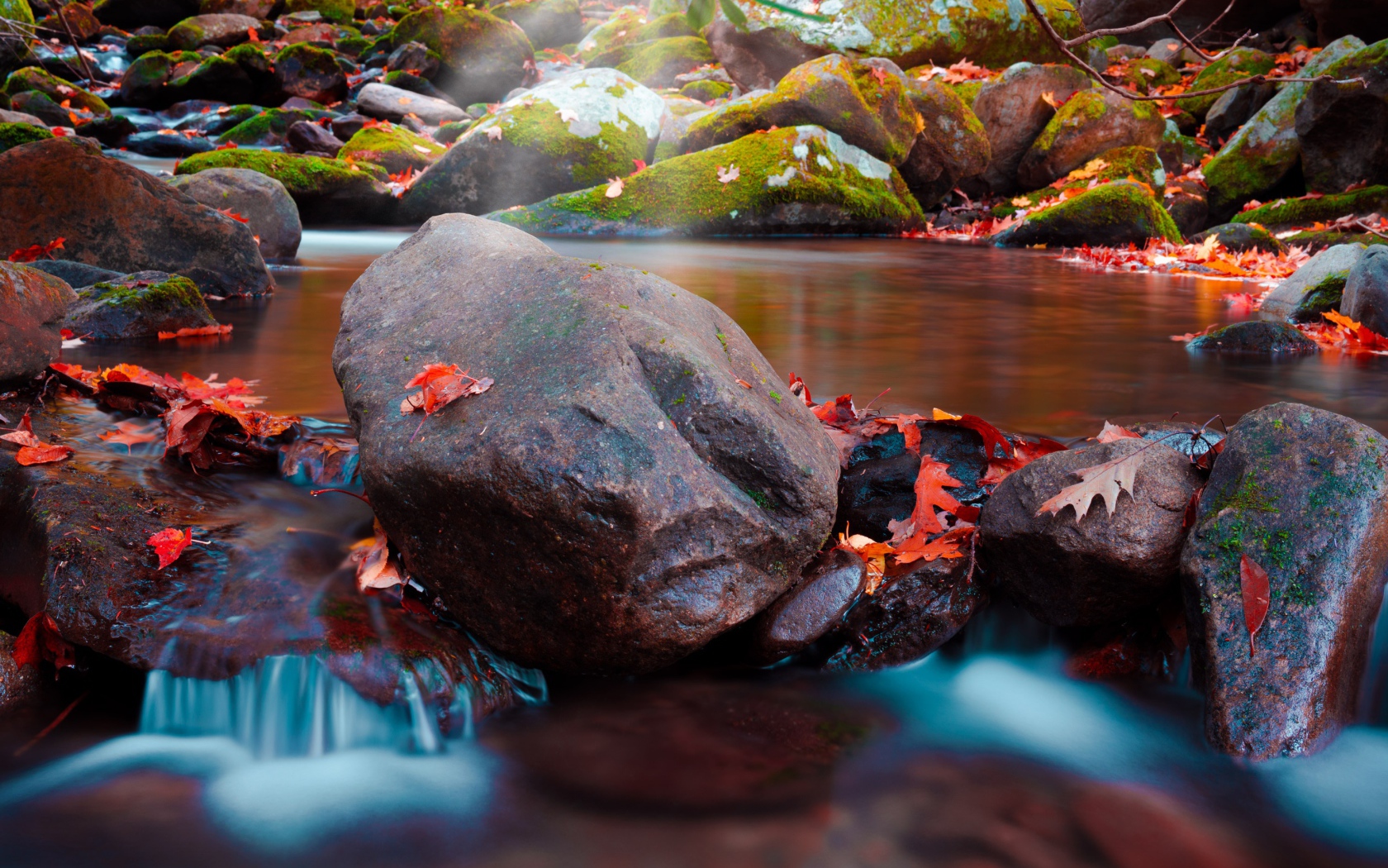 Большие мокрые камни с мхом в реке