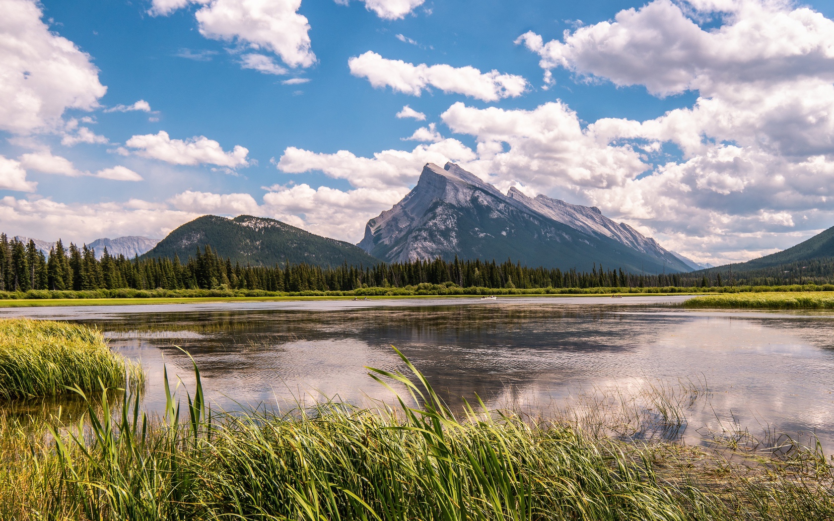 Красивое горное озеро под голубым небом с белыми облаками