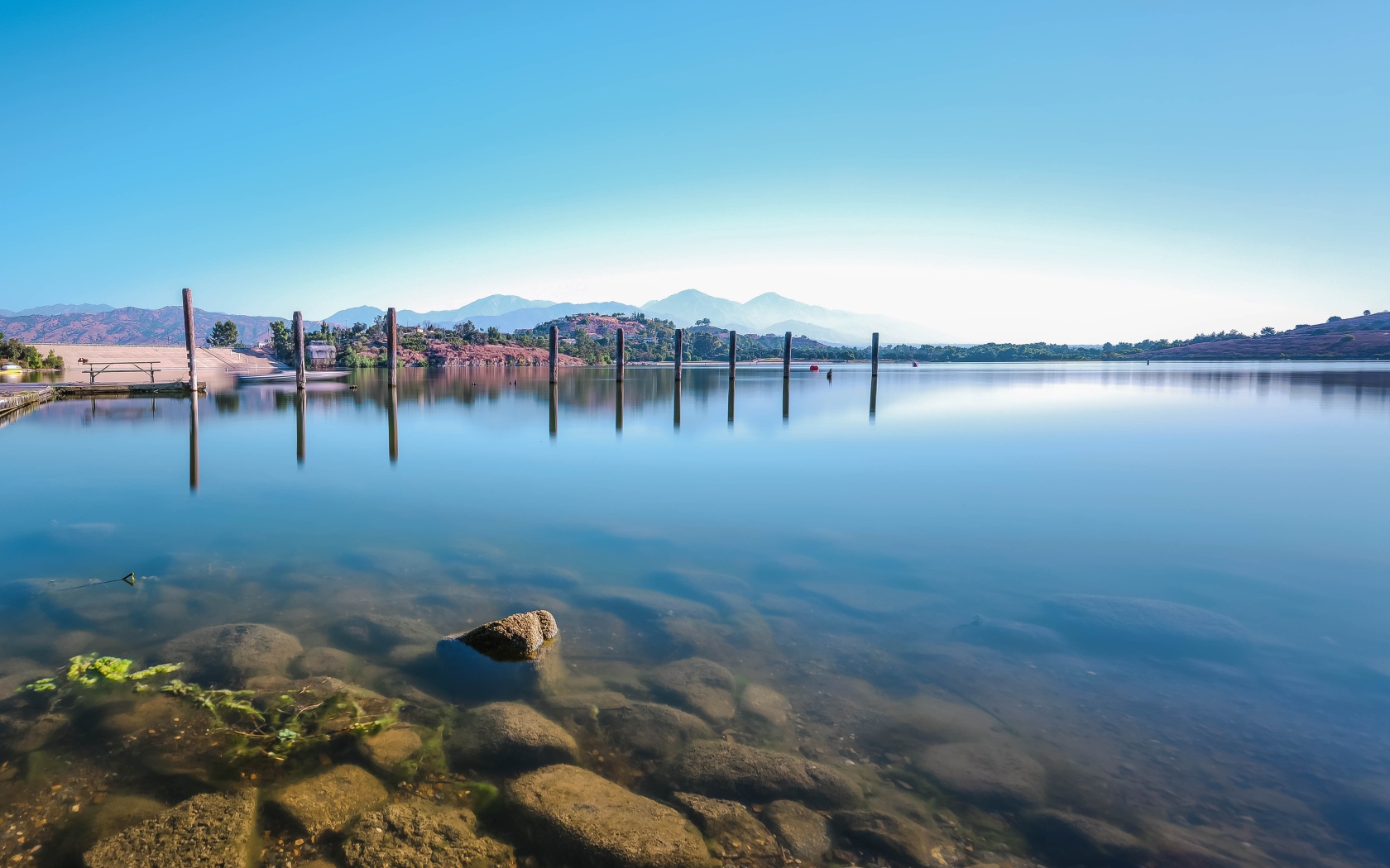 Камни в озере на фоне голубого неба