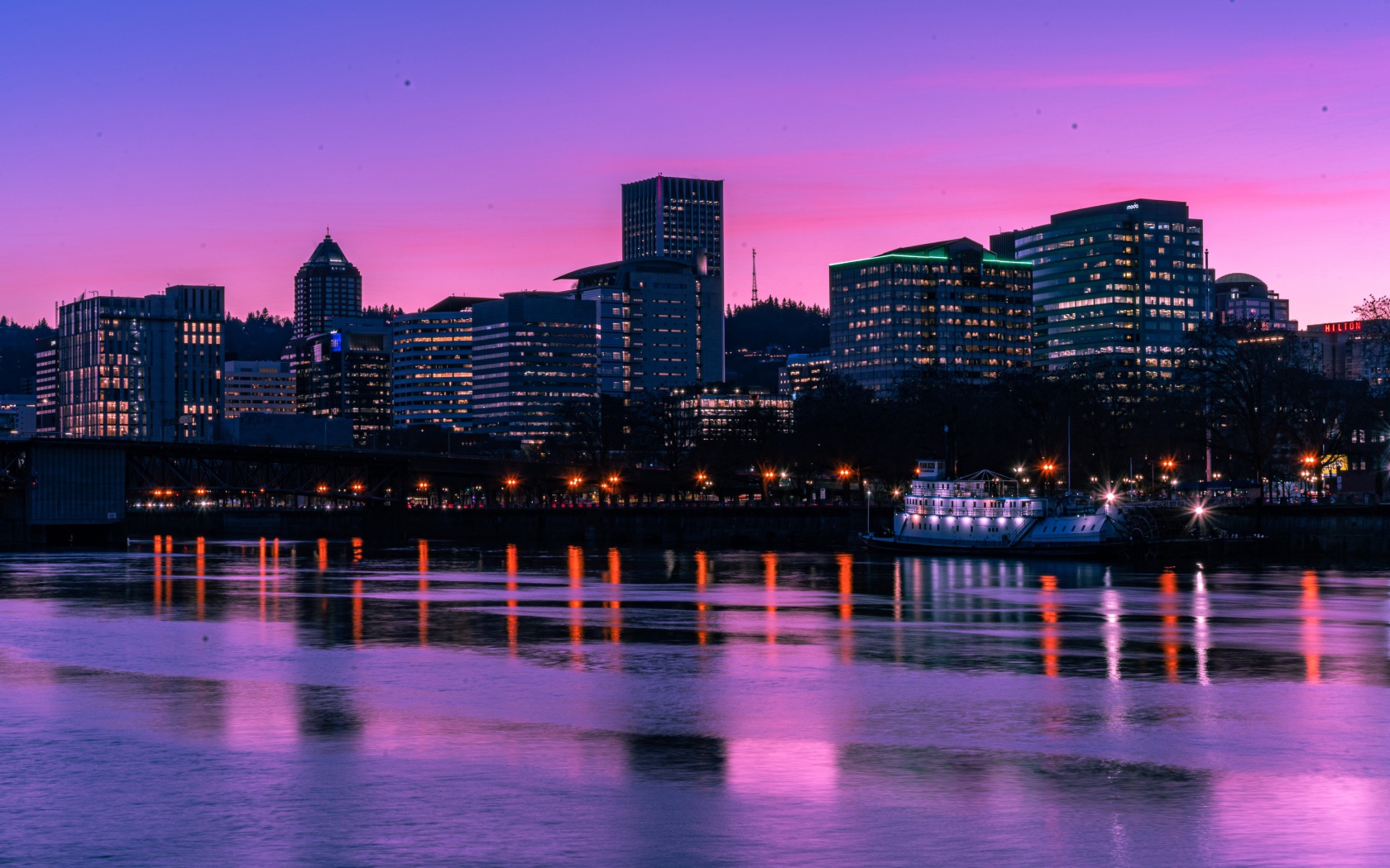 Сиреневый закат над ночным городом у реки