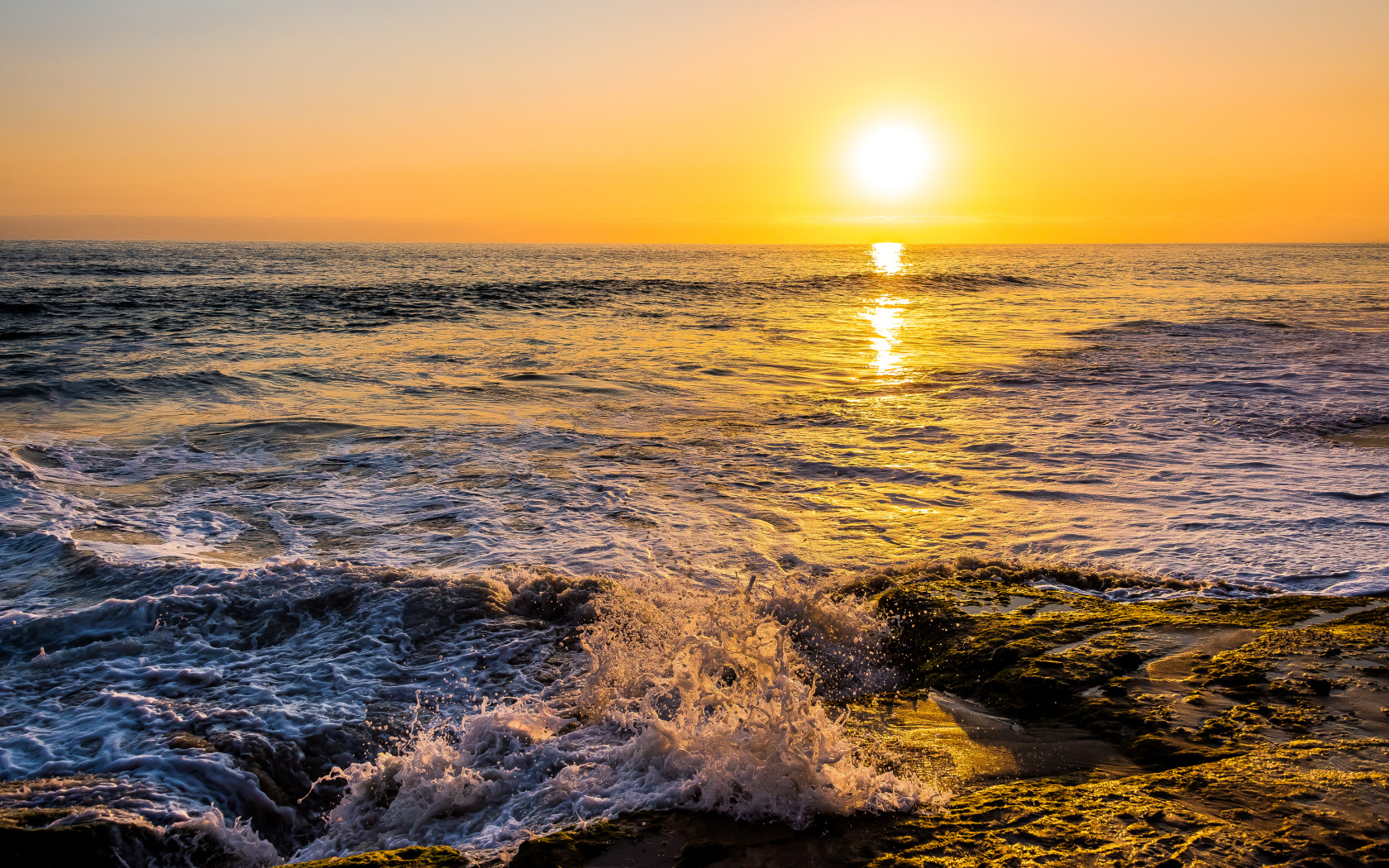 Белые волны бьются о берег на закате 