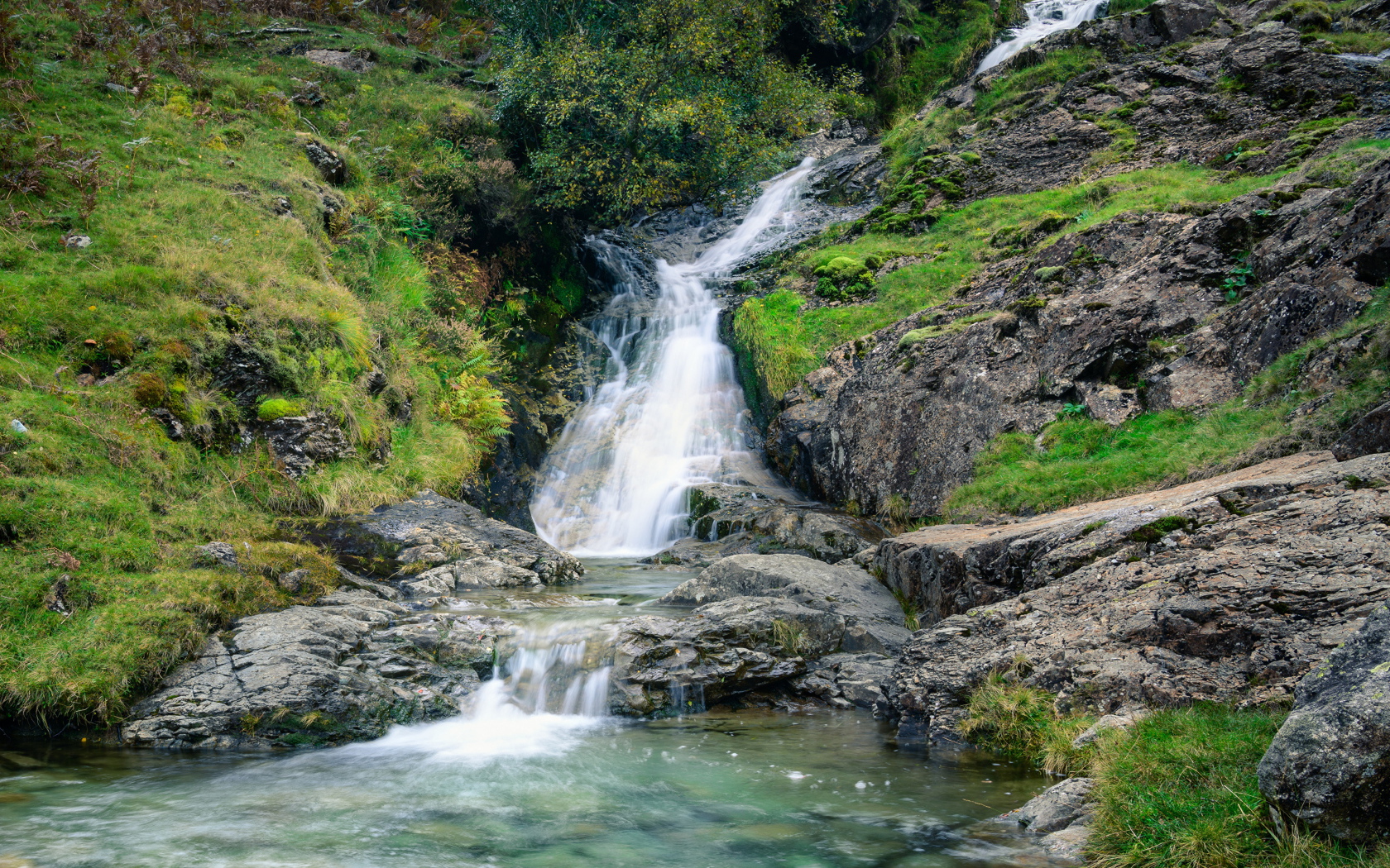 Горный ручей стекает по камням в реку 