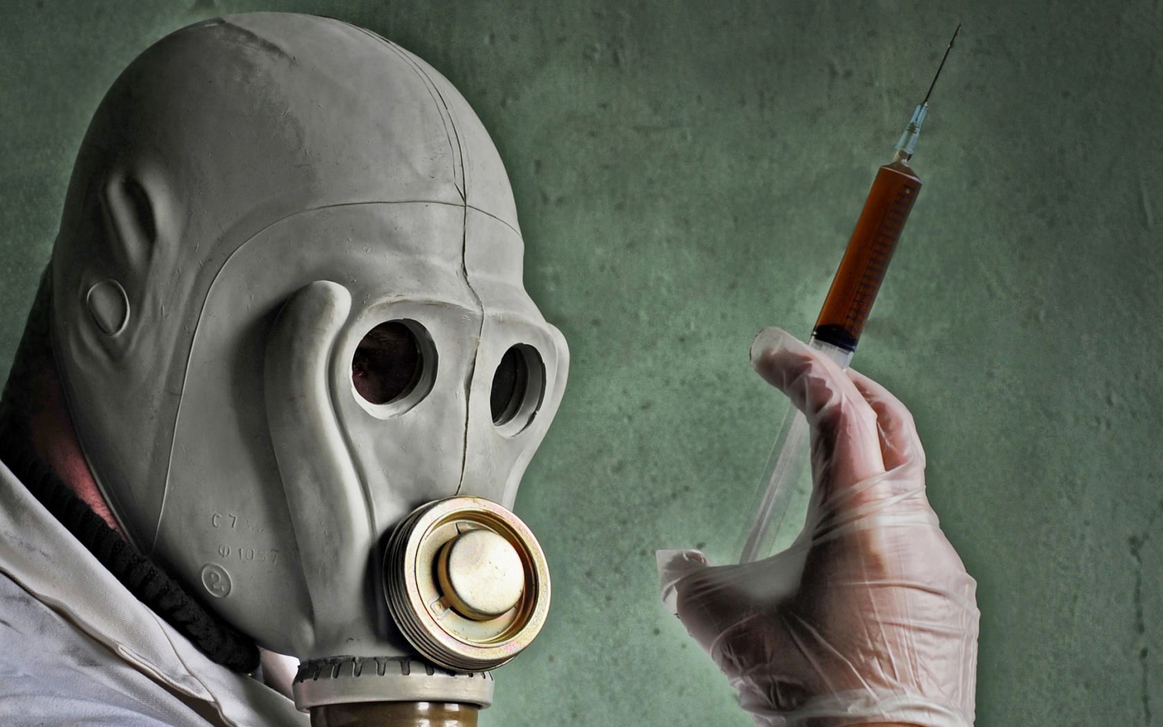 Мужчина в противогазе со шприцем в руках, пандемия коронавирус