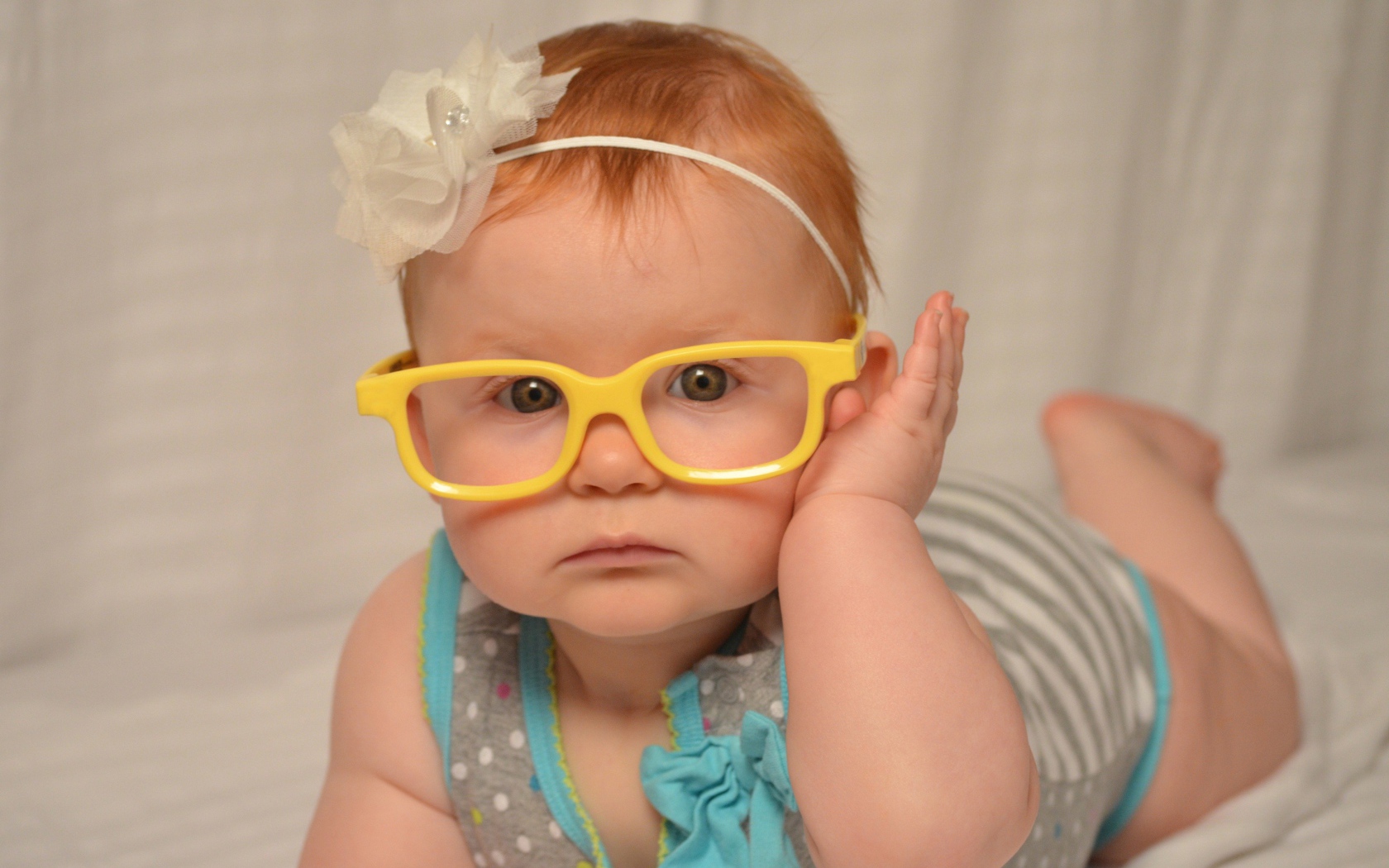 Маленькая красивая девочка в очках с обручем на голове