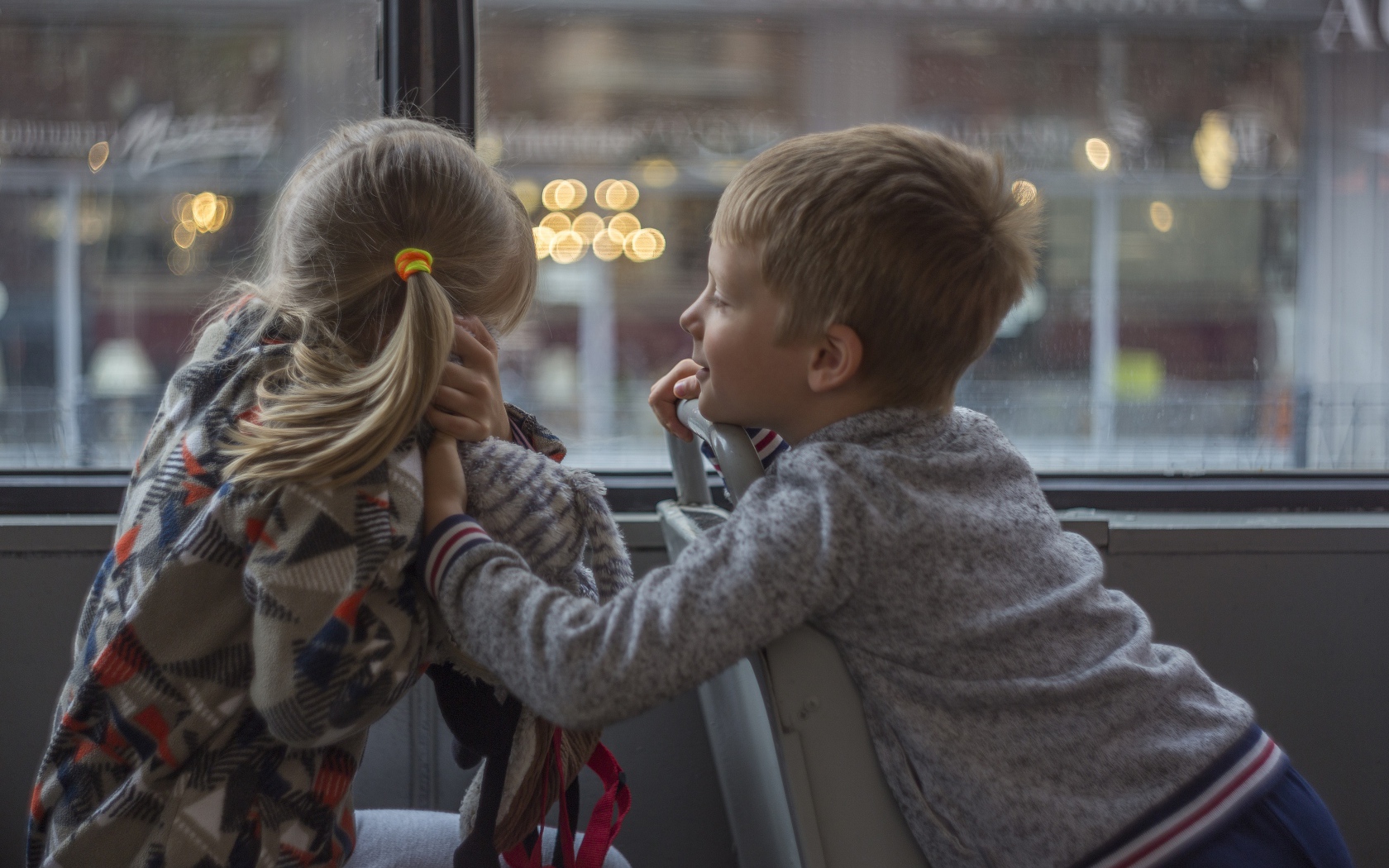 Маленькие девочка и мальчик сидят в автобусе 