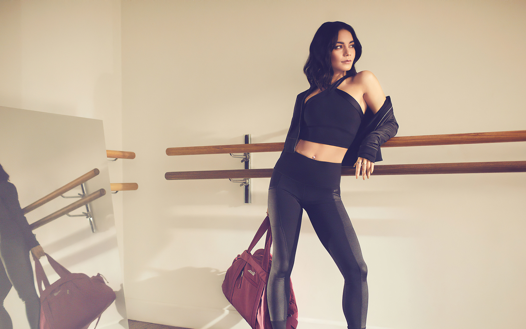 Актриса Ванесса Хадженс в черном костюме на тренировке