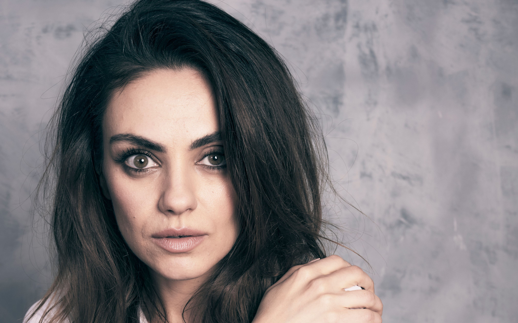 Американская актриса Мила Кунис на сером фоне