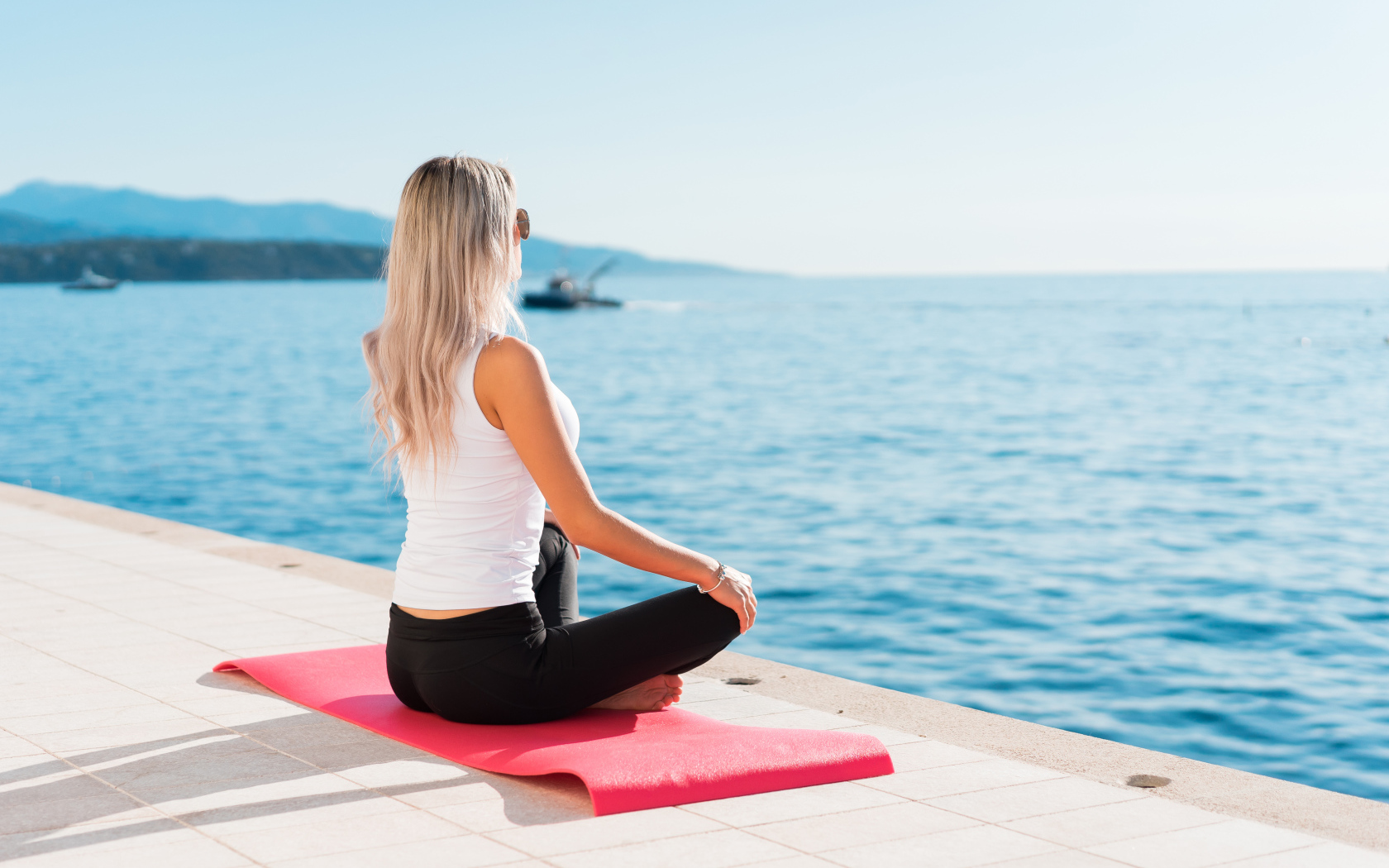 Девушка медитирует на берегу моря 