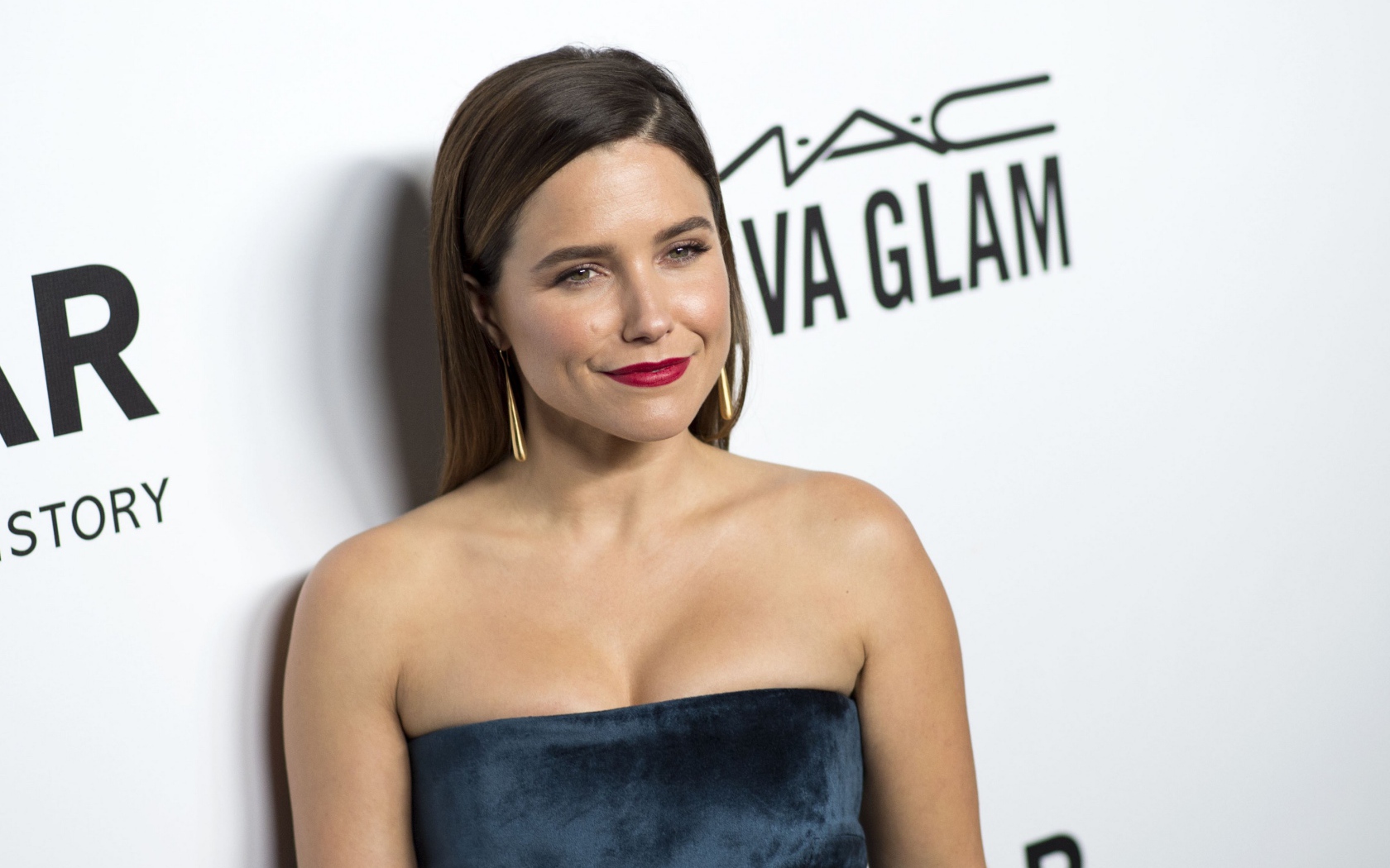 Улыбающаяся женщина, актриса София Буш у стены