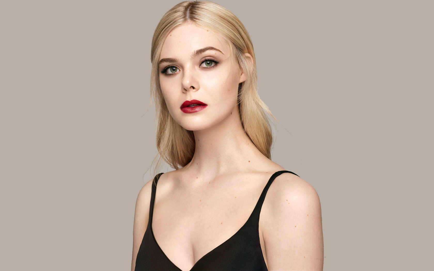 Нежная блондинка Эль Фаннинг на сером фоне