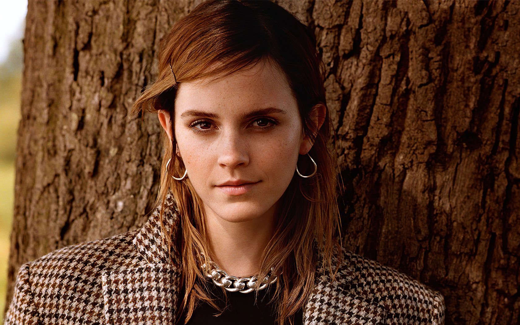 Молодая кареглазая девушка, актриса Эмма Уотсон у дерева