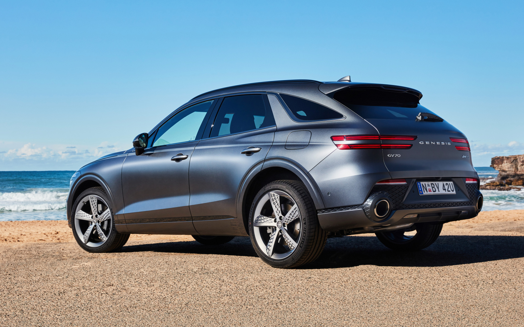 Серебристый автомобиль Genesis GV70 3.5T AWD 2021 года вид сзади 