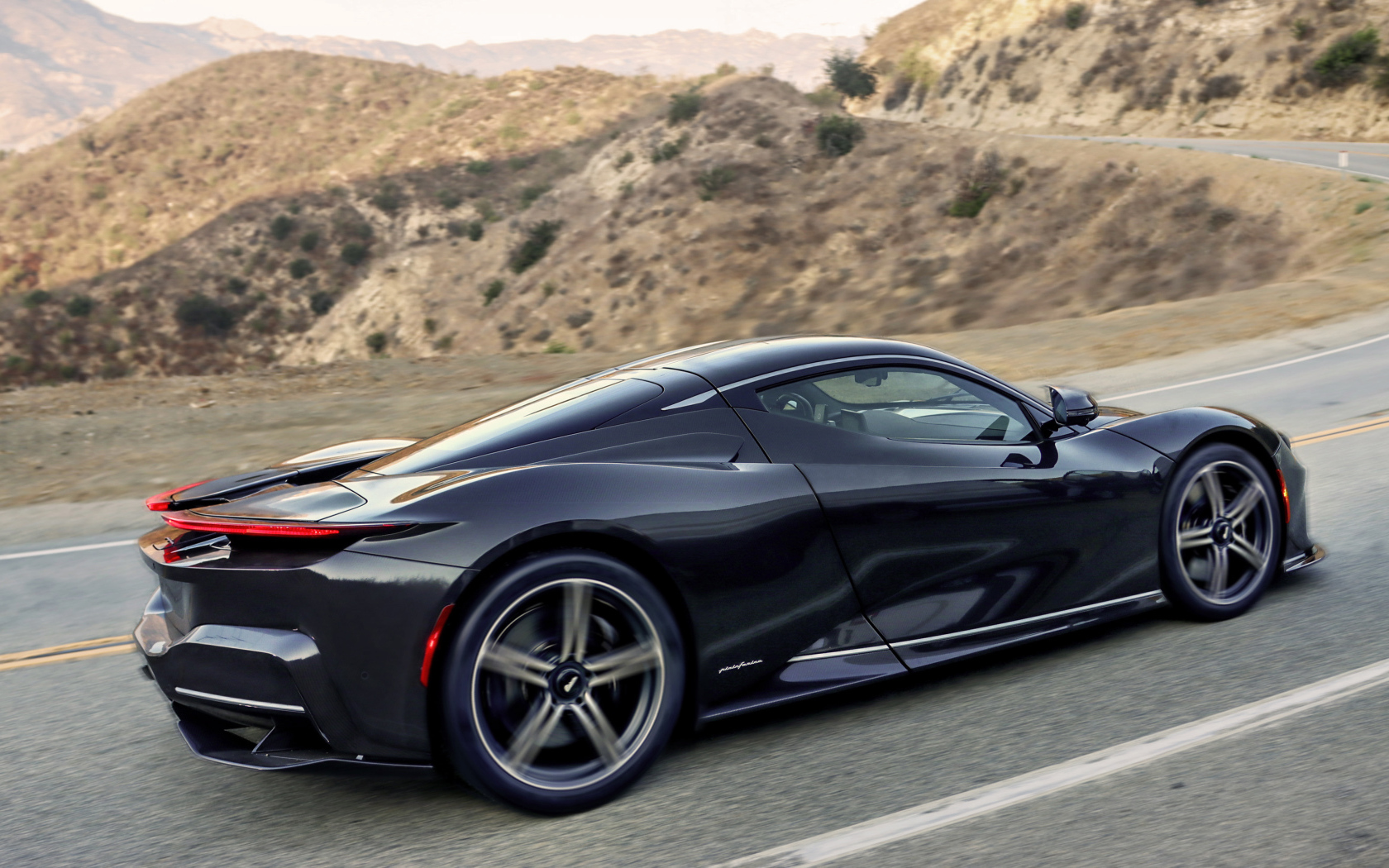 Черный Pininfarina Battista, 2022 года на трассе в горах