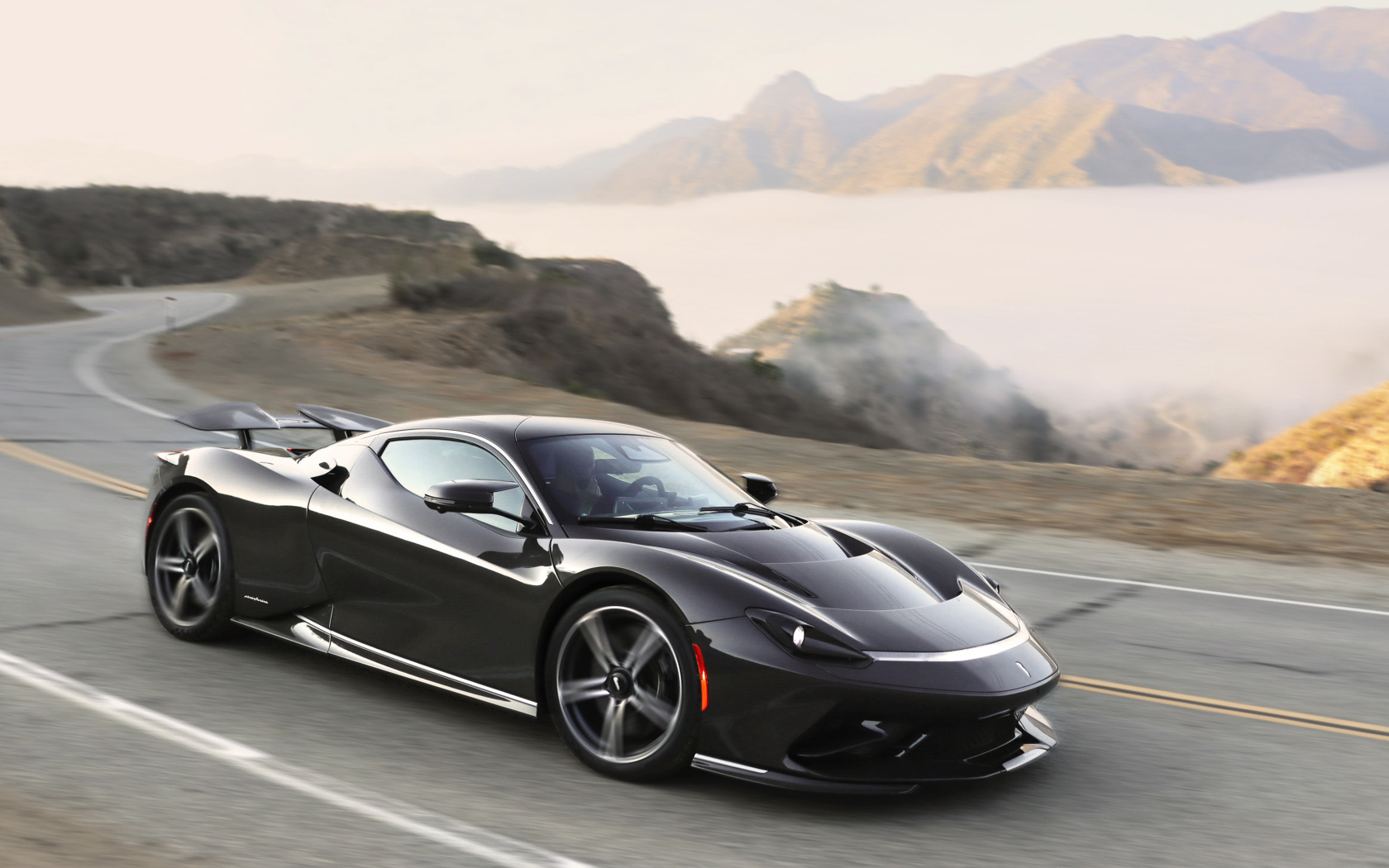 Черный спортивный автомобиль Pininfarina Battista,  2022 года на трассе