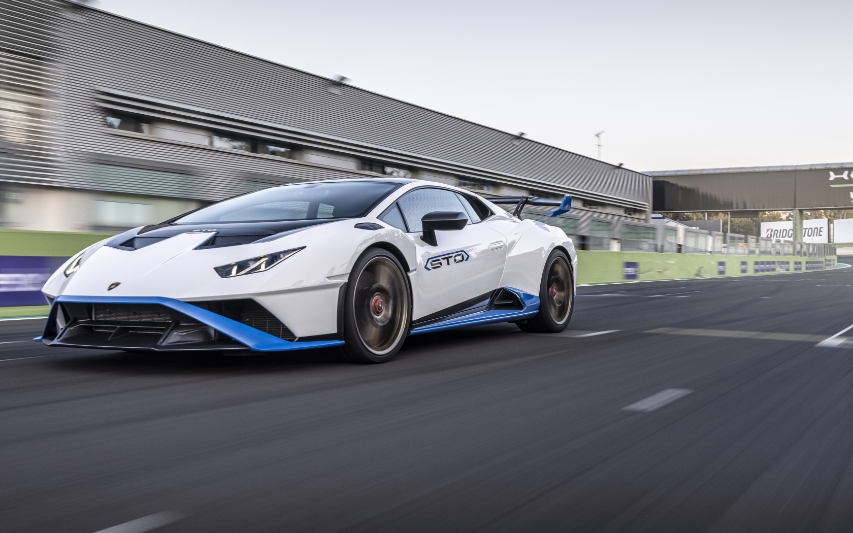 Белый автомобиль Lamborghini Huracán STO 2021 года на стадионе 