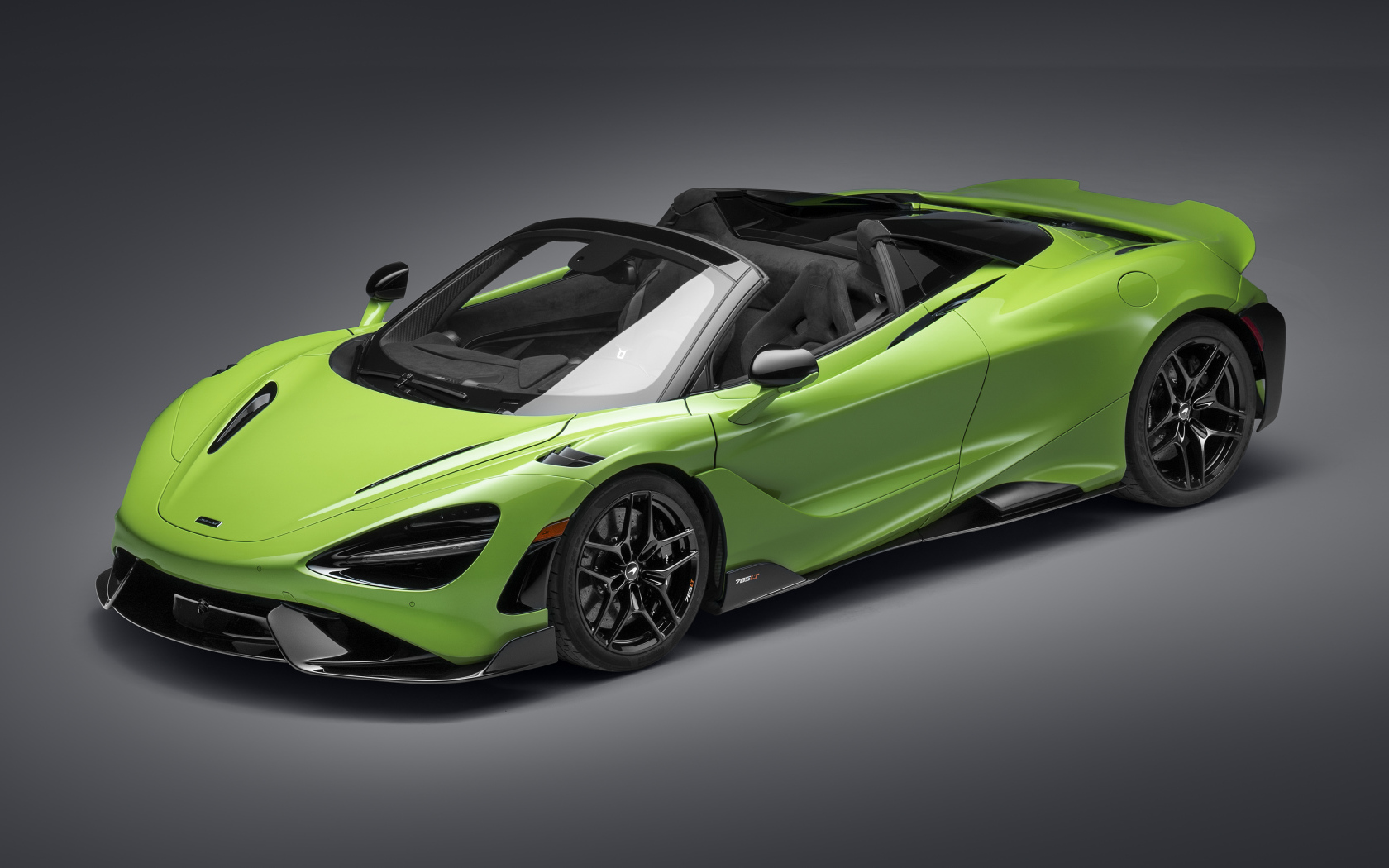 Зеленый  кабриолет McLaren 765LT Spider 2022 года на сером фоне