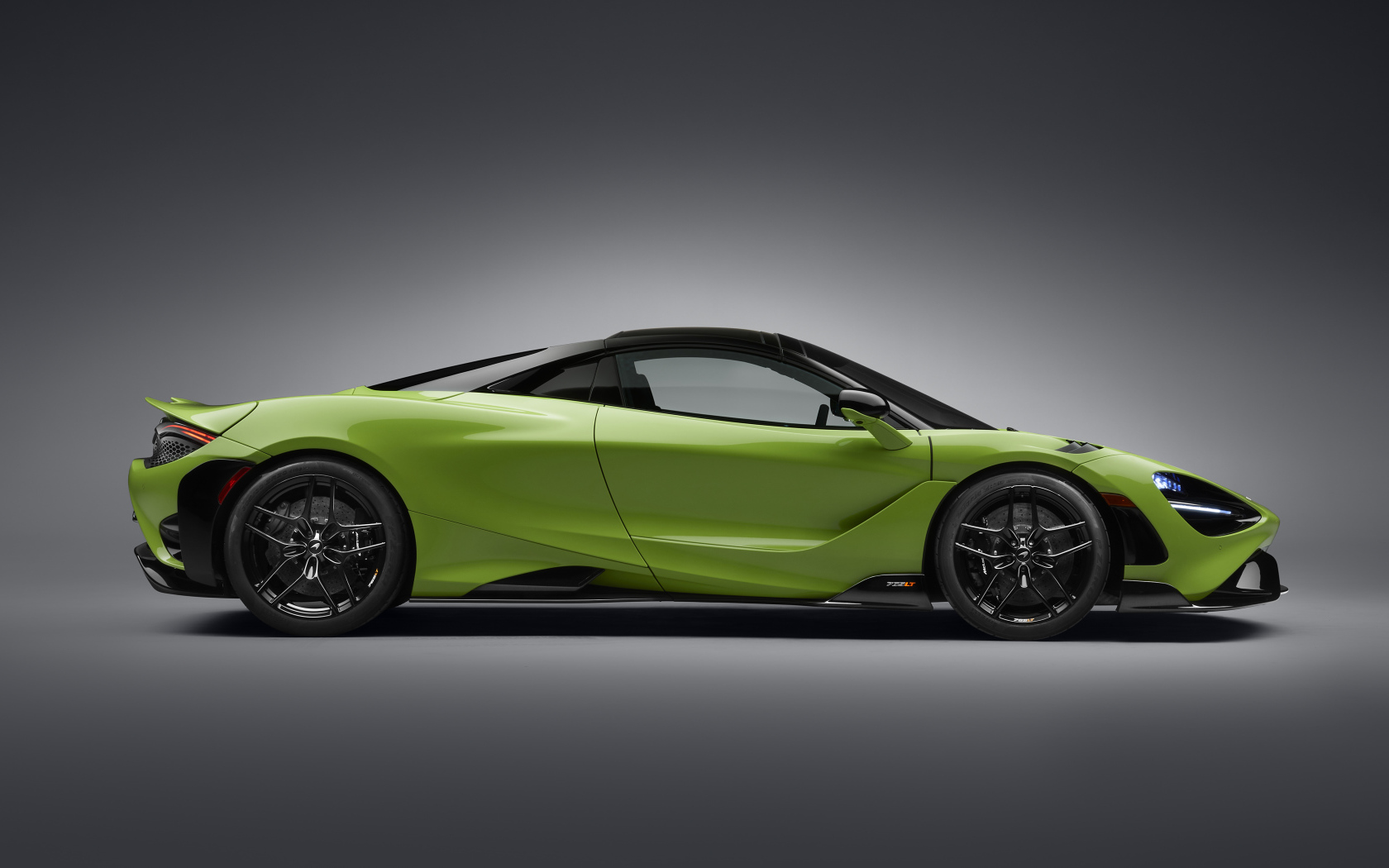 Зеленый автомобиль McLaren 765LT Spider 2022 года вид сбоку