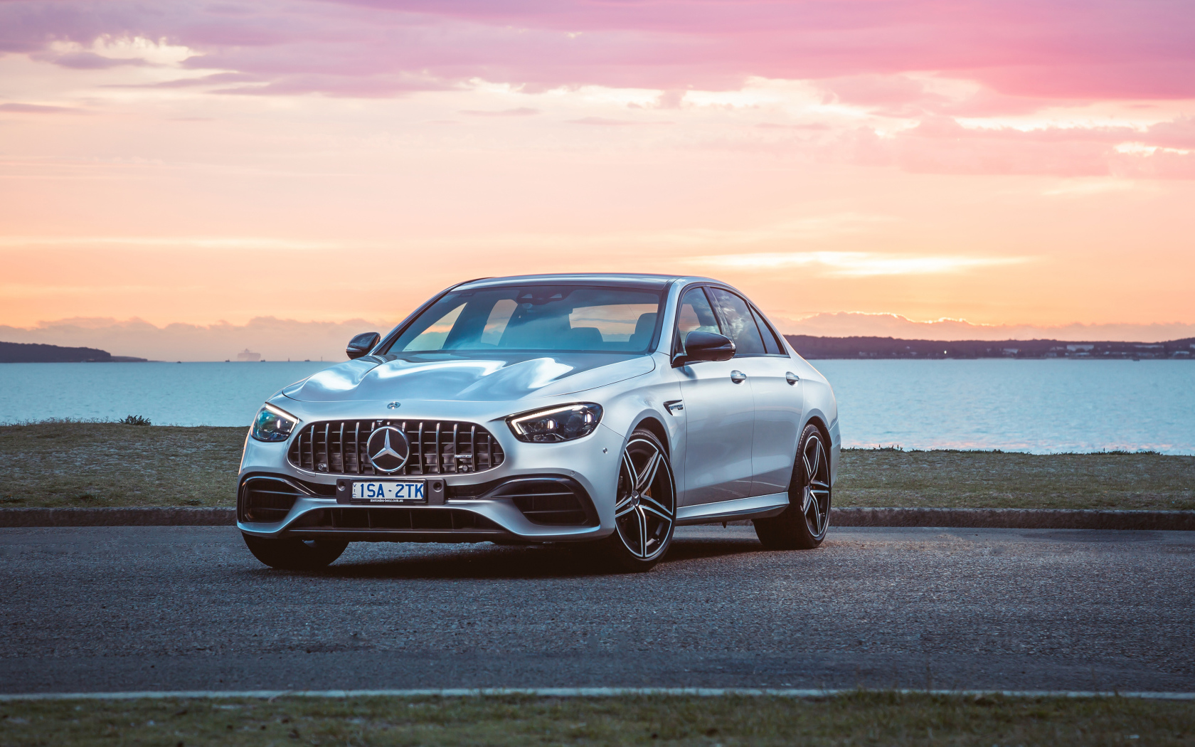 Серебристый автомобиль Mercedes-AMG E 63 S 4MATIC+ 2021 года у моря