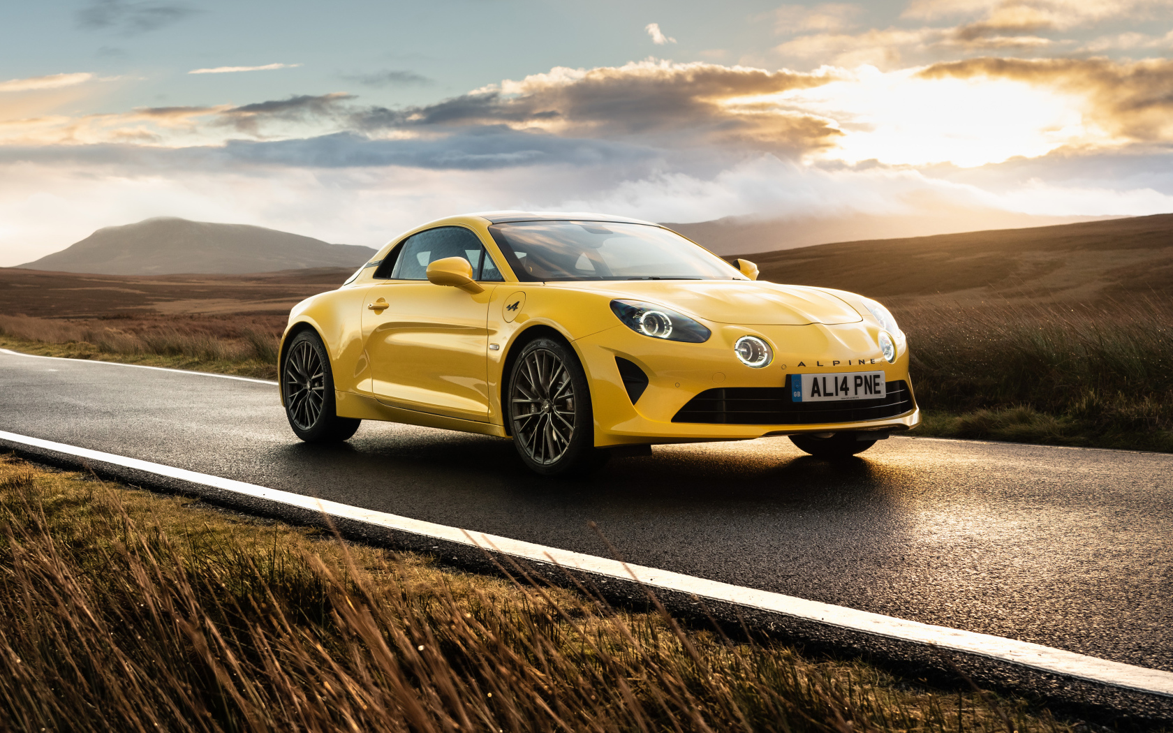 Желтый автомобиль Alpine A110, 2021 года на фоне заката