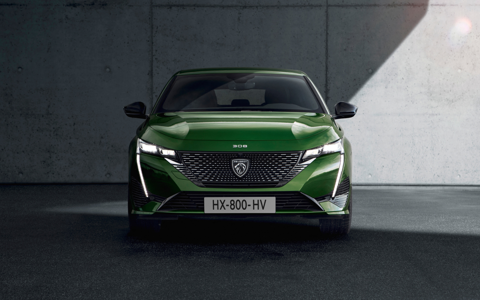 Автомобиль Peugeot 308, 2021 года вид спереди на фоне стены