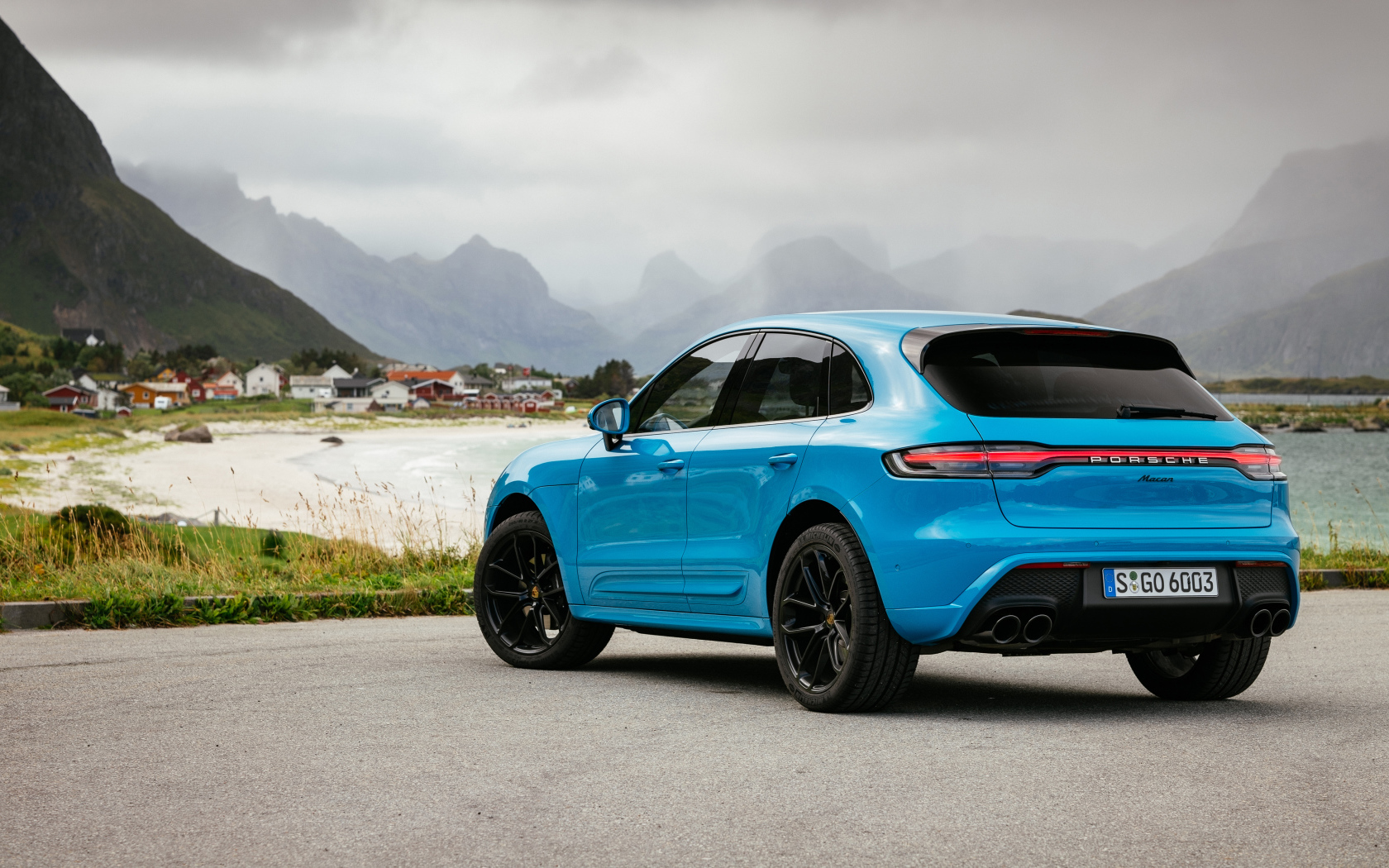 Голубой автомобиль Porsche Macan 2021 года вид сзади