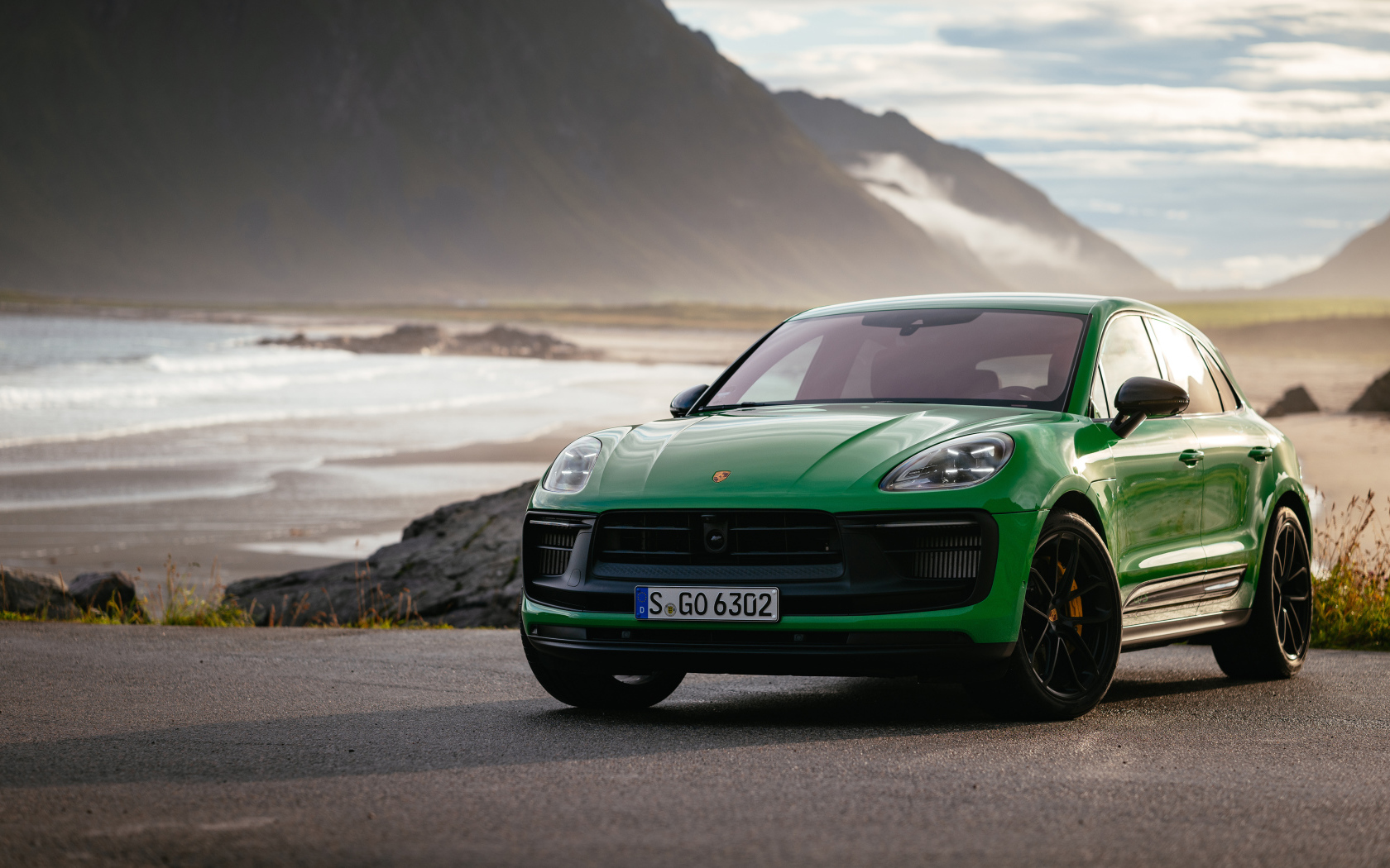 Зеленый Porsche Macan GTS Sport Package 2021 года на фоне гор