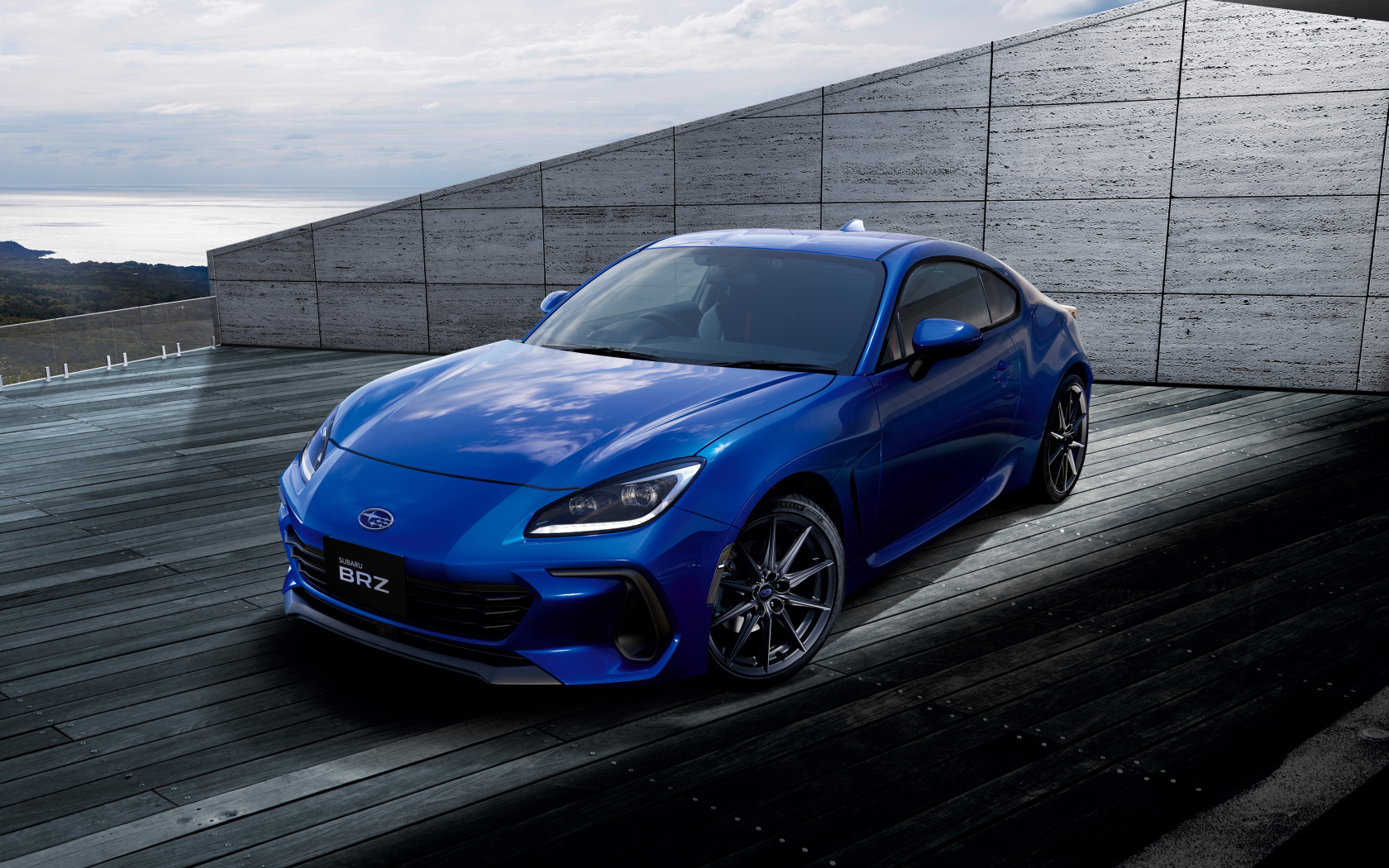 Синий автомобиль Subaru BRZ 2021 года у серой стены