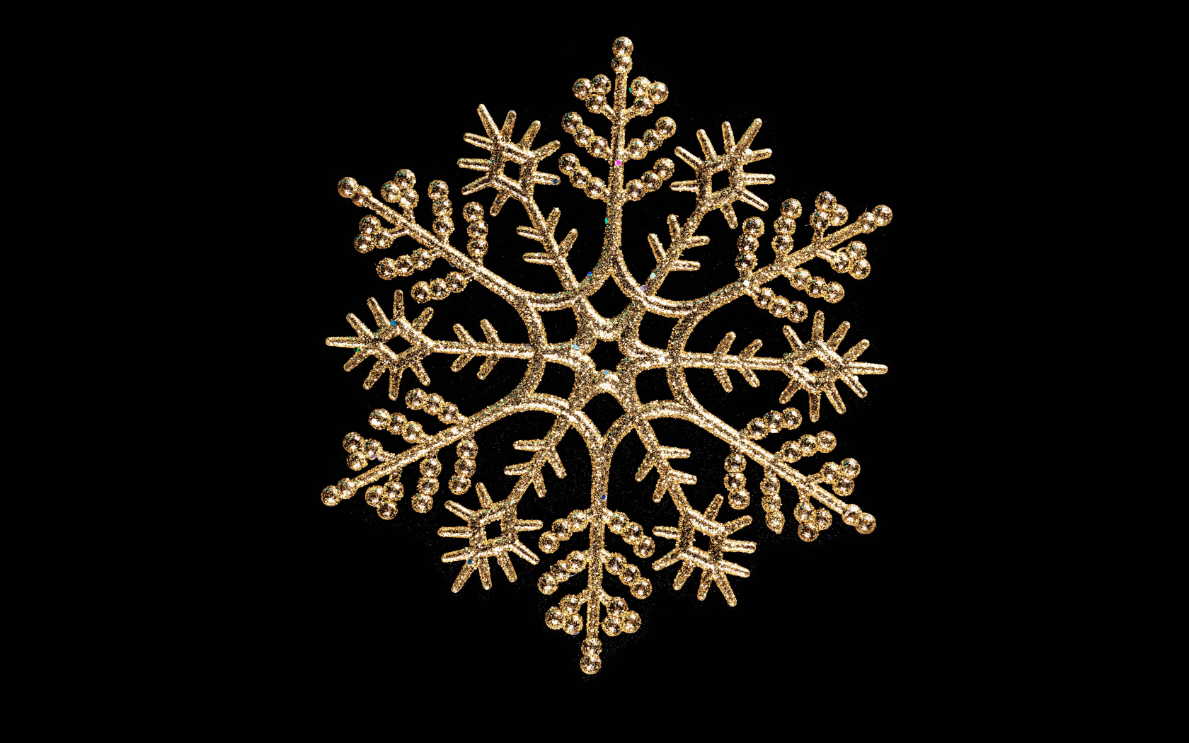 Красивая золотистая снежинка на черном фоне