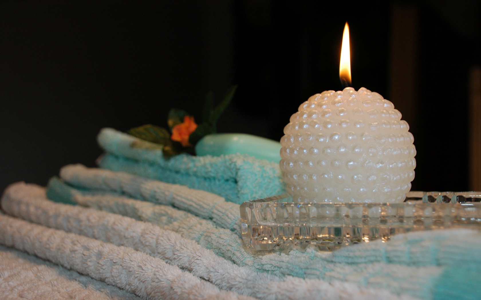 Красивая зажженная свеча с полотенцами