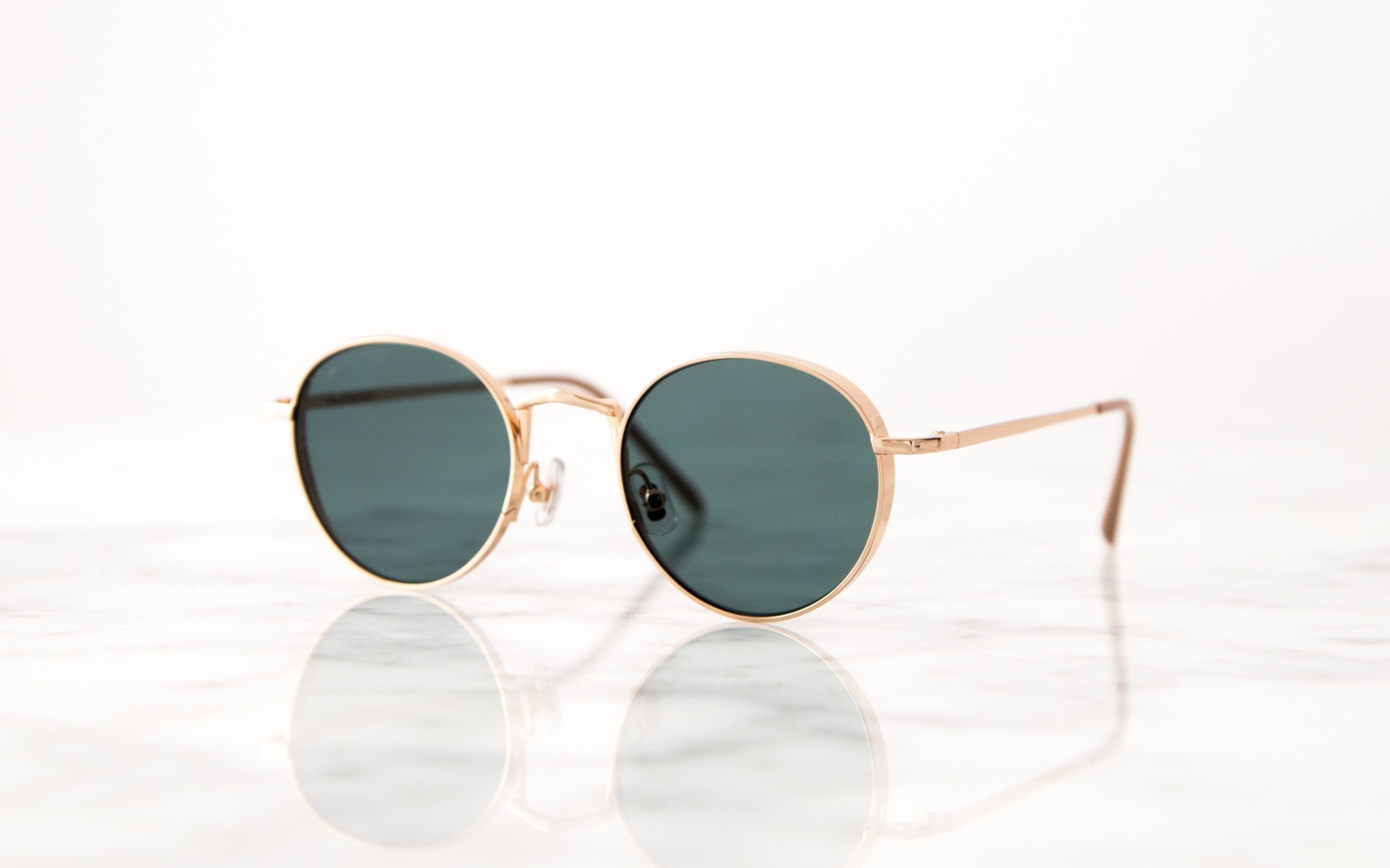 Солнечные очки лежат на зеркальной поверхности