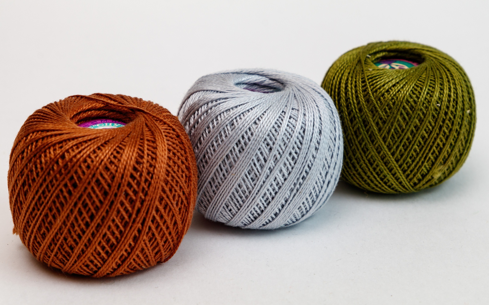 Три клубка пряжи на белом фоне 