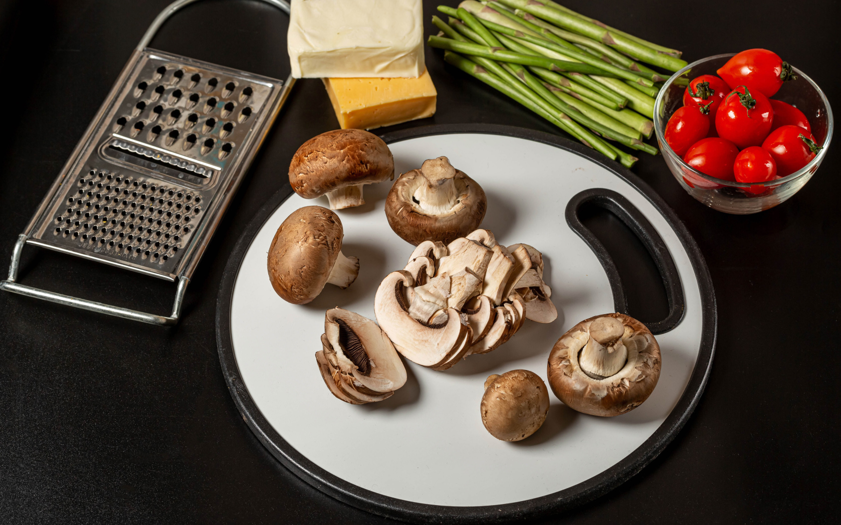 Шампиньоны на столе со спаржей и помидорами 