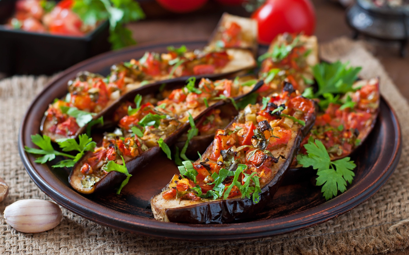 Баклажаны начиненные овощами на тарелке 