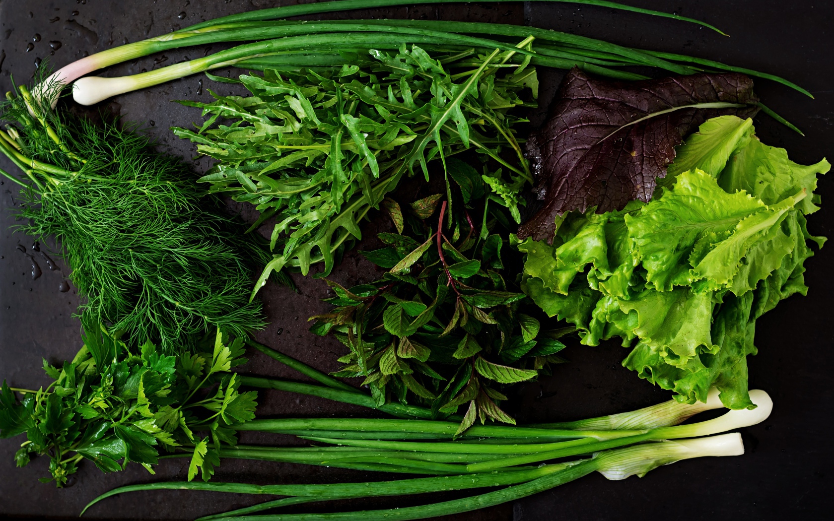 Свежая чистая зелень на черном столе