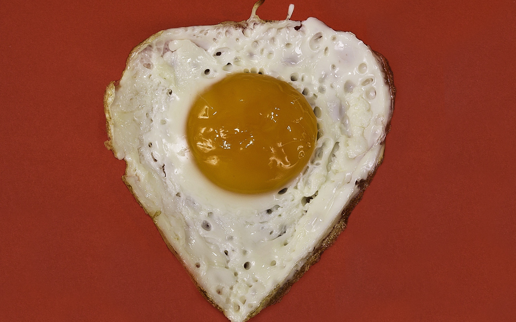 Яичница глазунья на красном фоне