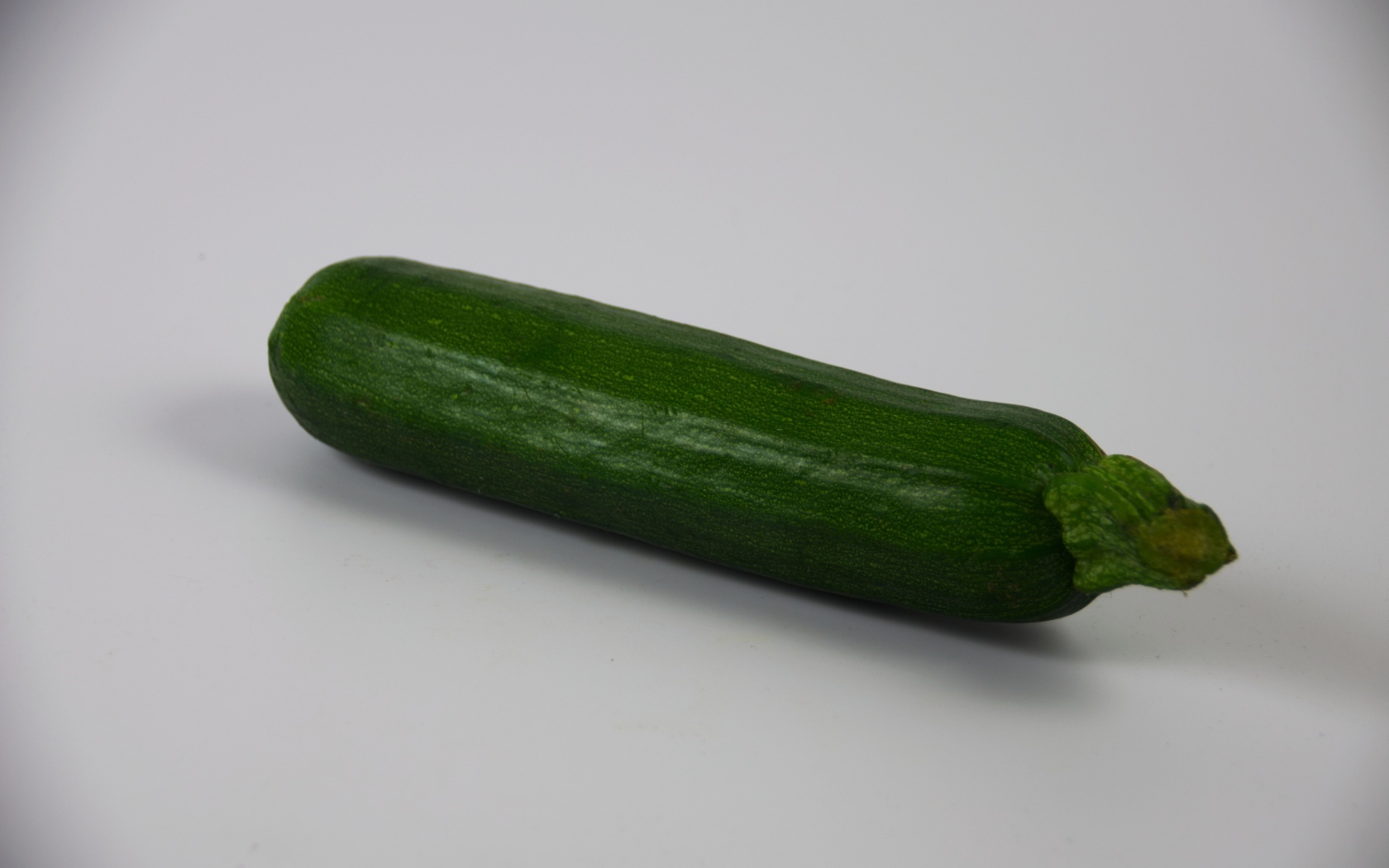 Зеленый кабачок на сером фоне